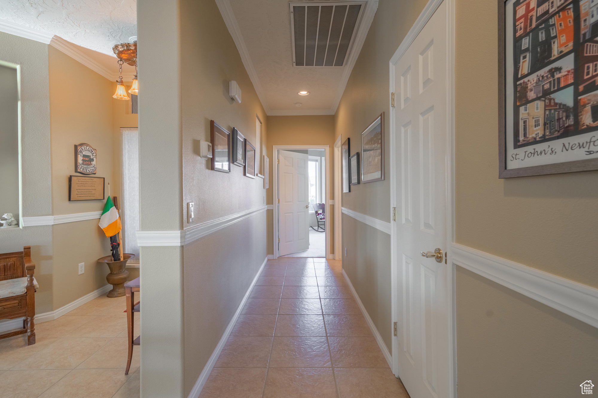 Corridor to 2nd bed & bath with light tile patterned floors, and ornamental molding