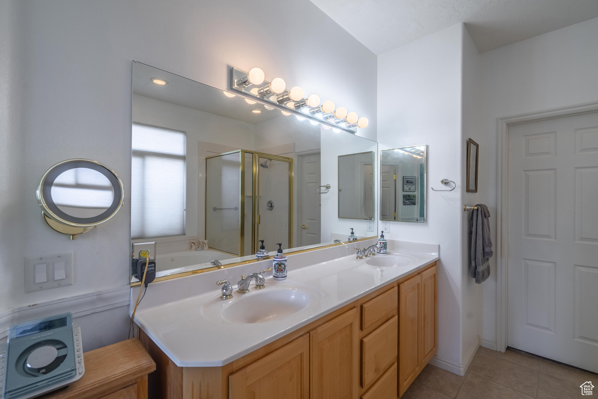 Bathroom featuring tile patterned flooring, vanity, and plus walk in shower