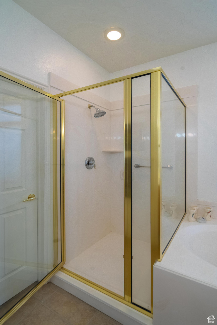 Bathroom featuring tile patterned floors and shower with separate bathtub