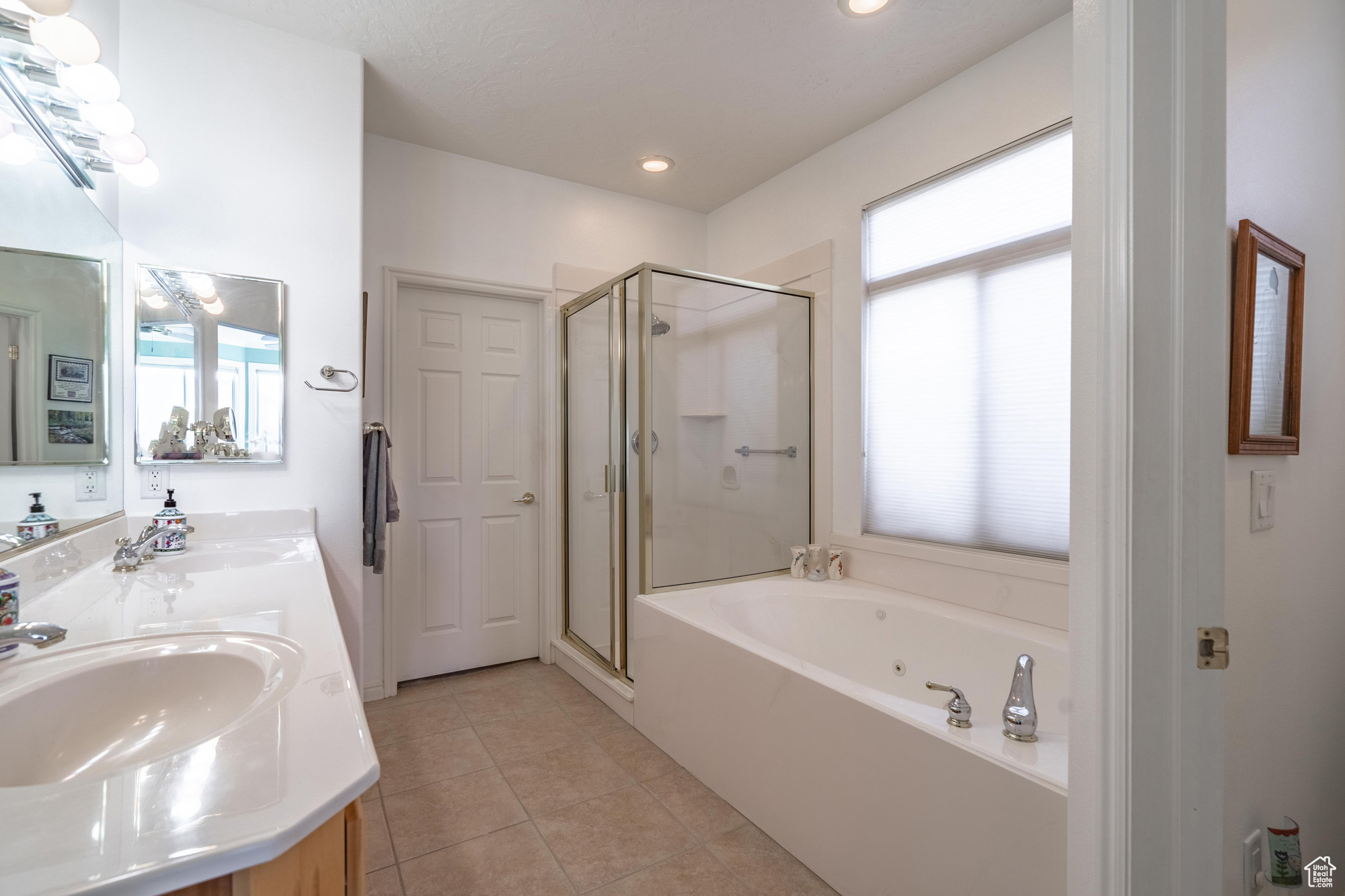 Bathroom with tile patterned floors, vanity, and shower with separate bathtub