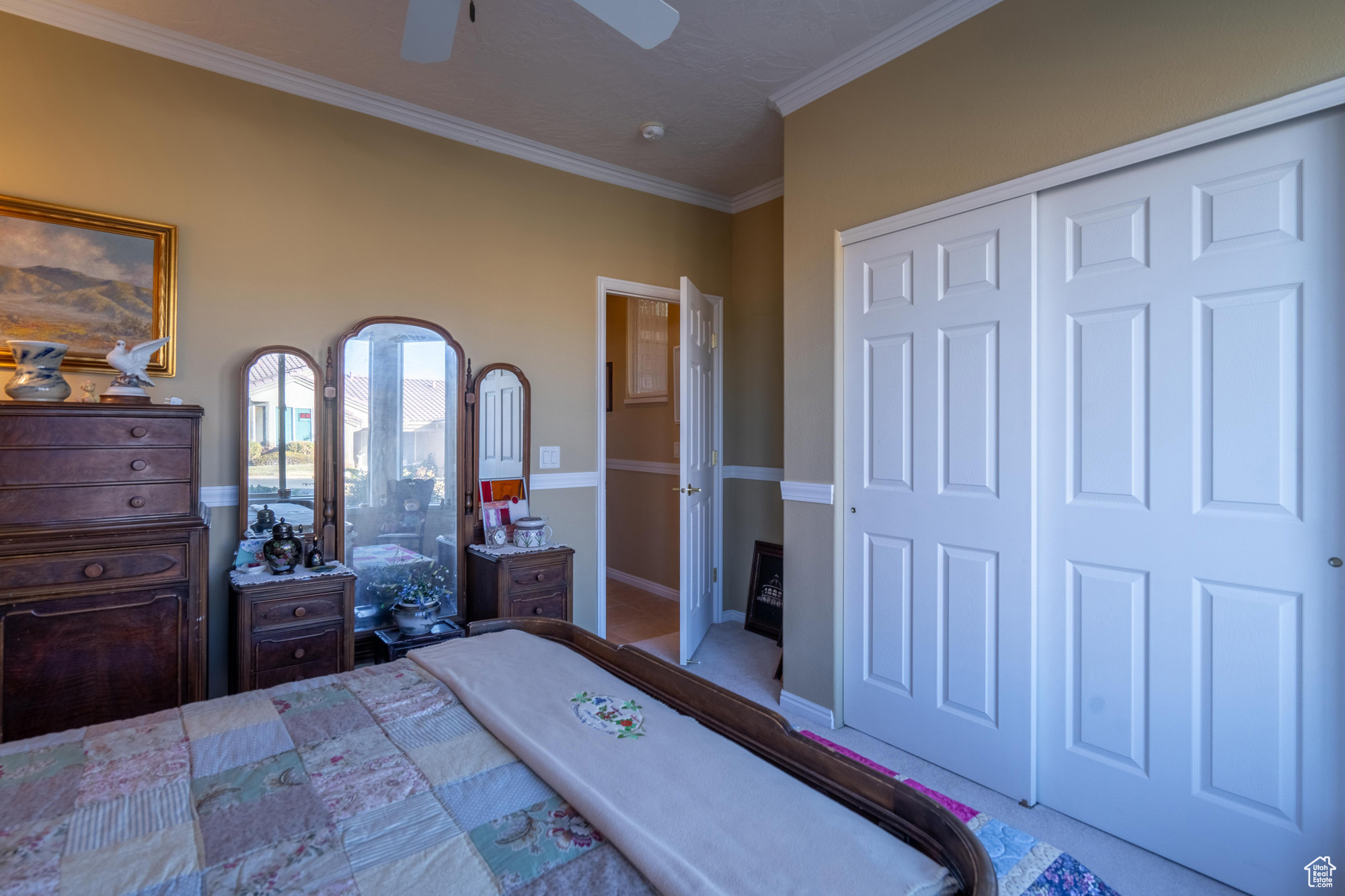 Carpeted 2nd bedroom featuring a closet, ornamental molding, and ceiling fan