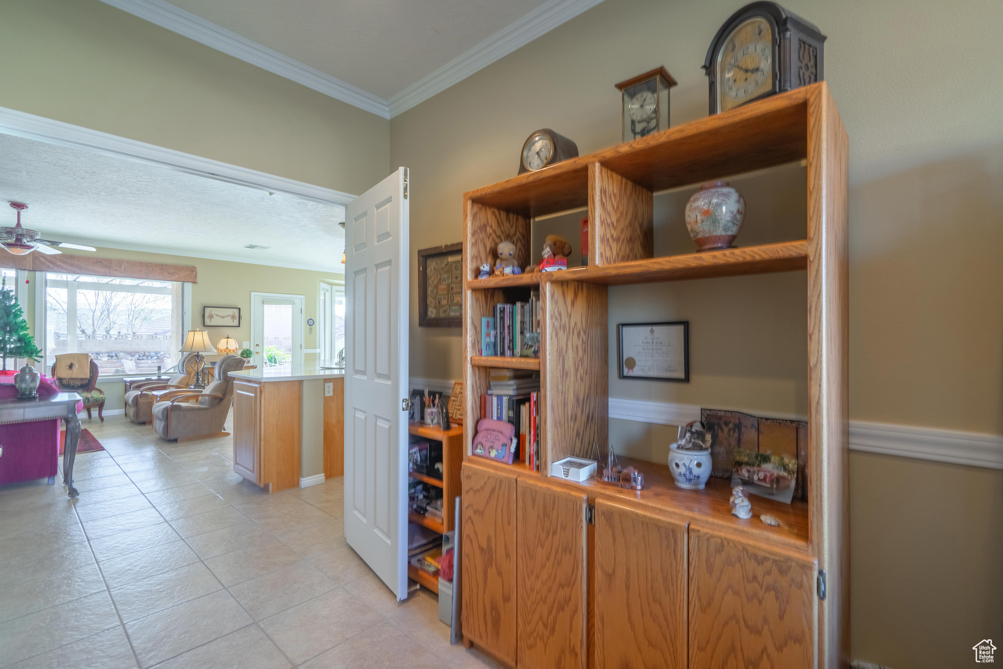 Home office featuring crown molding, ceiling fan, and light tile patterned flooring