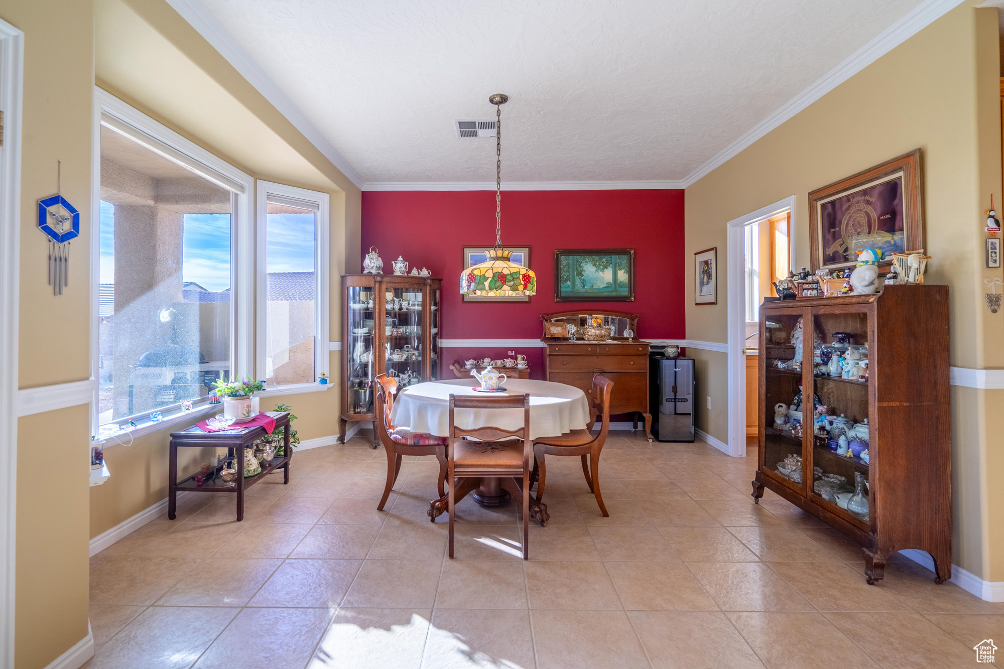 Dining space featuring light tile patterned flooring and ornamental molding