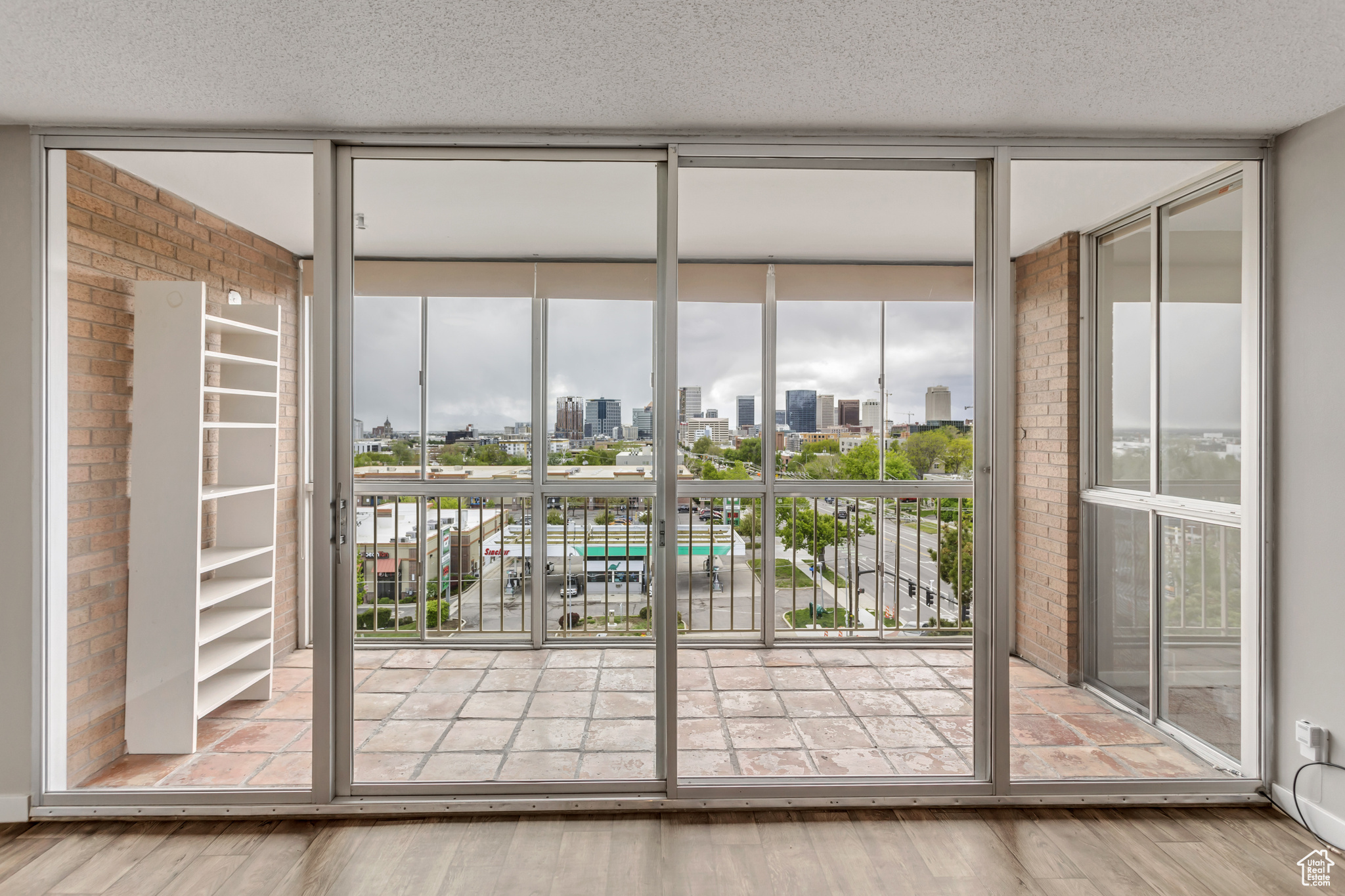 Doorway to outside with expansive windows, wood-type flooring, and a textured ceiling