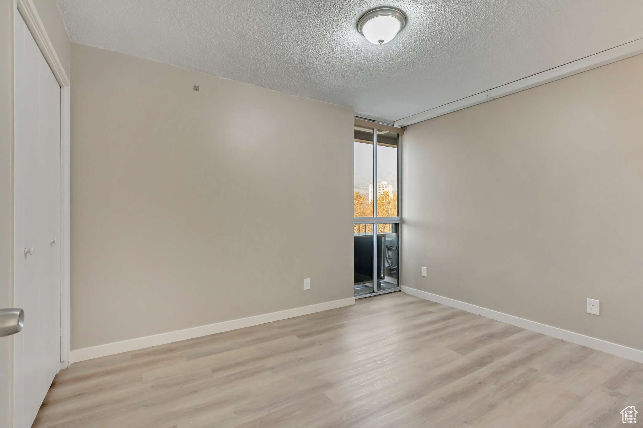 Unfurnished room featuring a textured ceiling and light hardwood / wood-style flooring