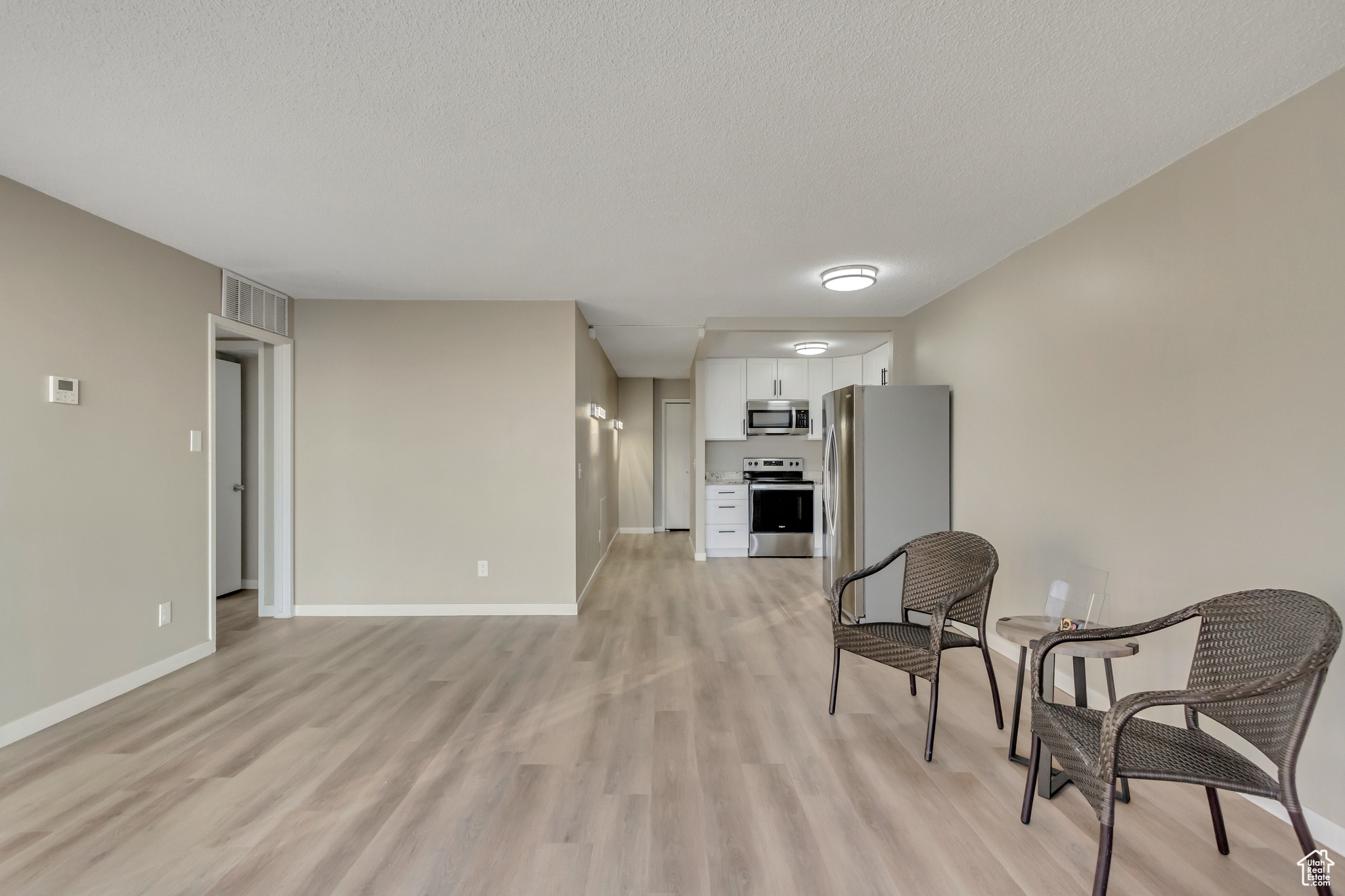 Sitting room featuring light wood-type flooring and a textured ceiling