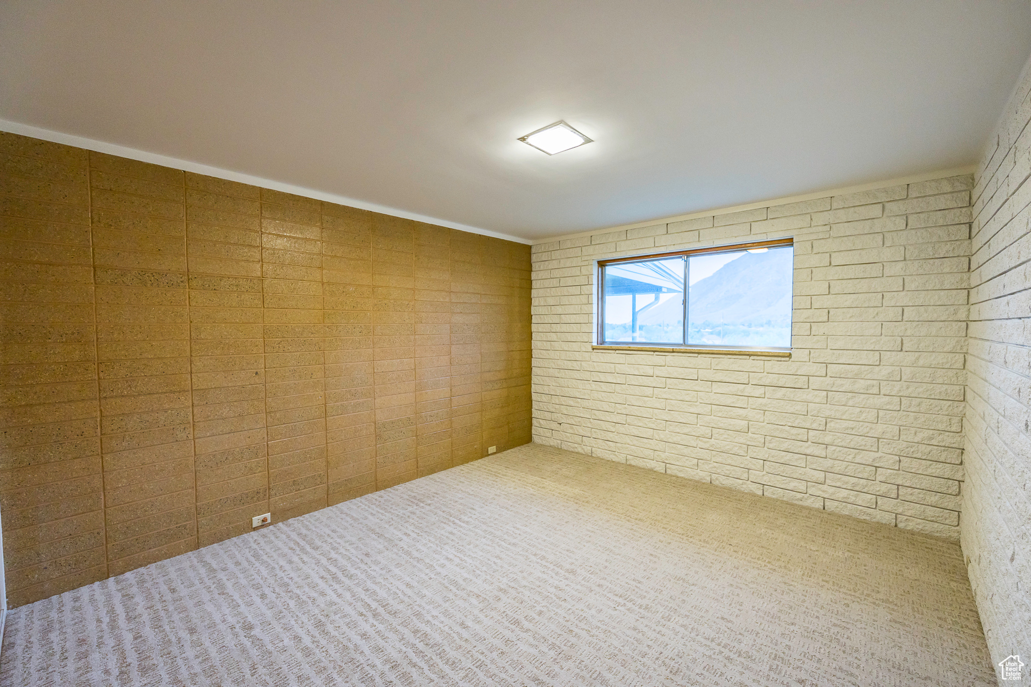 Unfurnished room featuring crown molding and brick wall