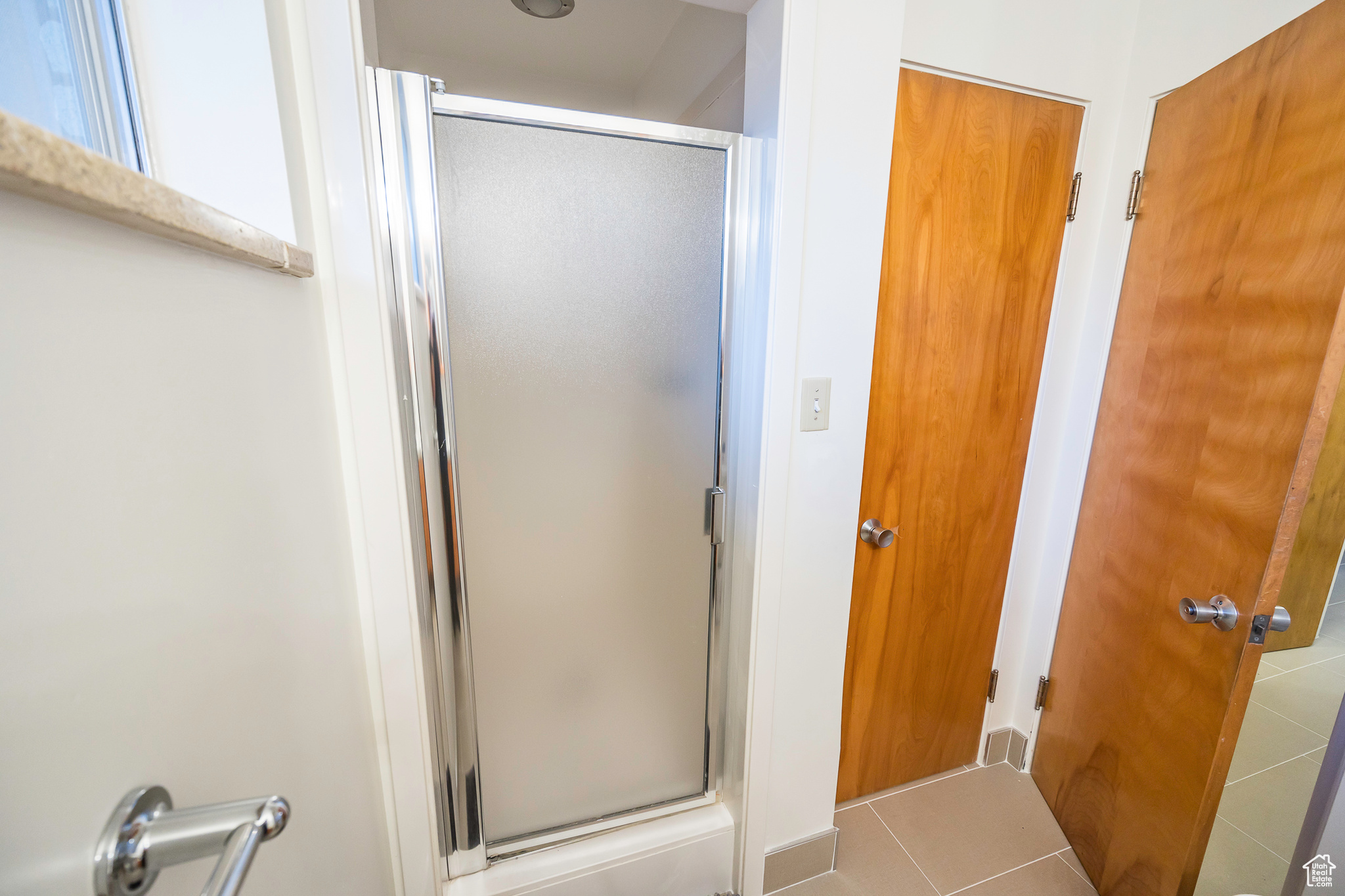 Bathroom featuring tile patterned flooring and a shower with door