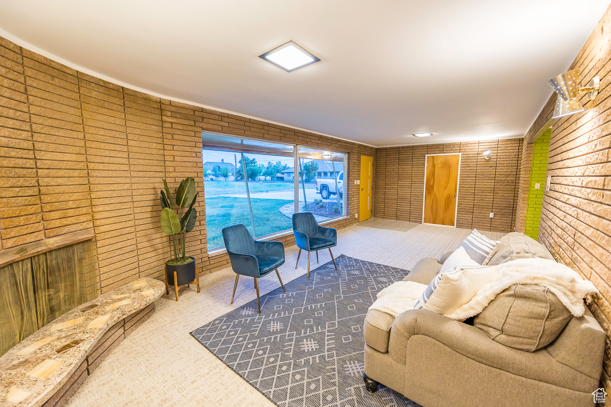 Carpeted living room with brick wall