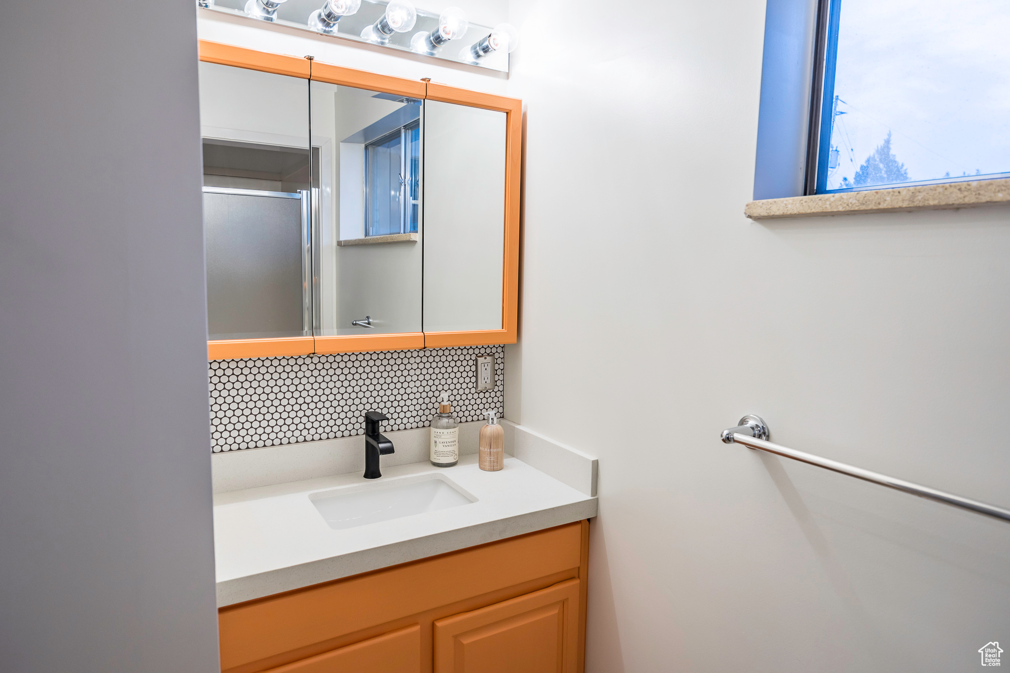 Bathroom featuring decorative backsplash and vanity