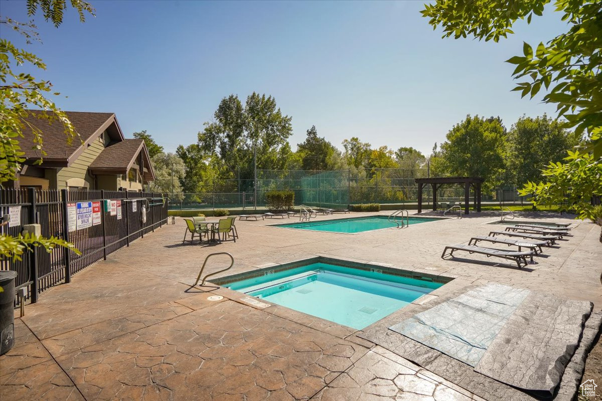 View of pool with a patio area, a pergola, and a hot tub