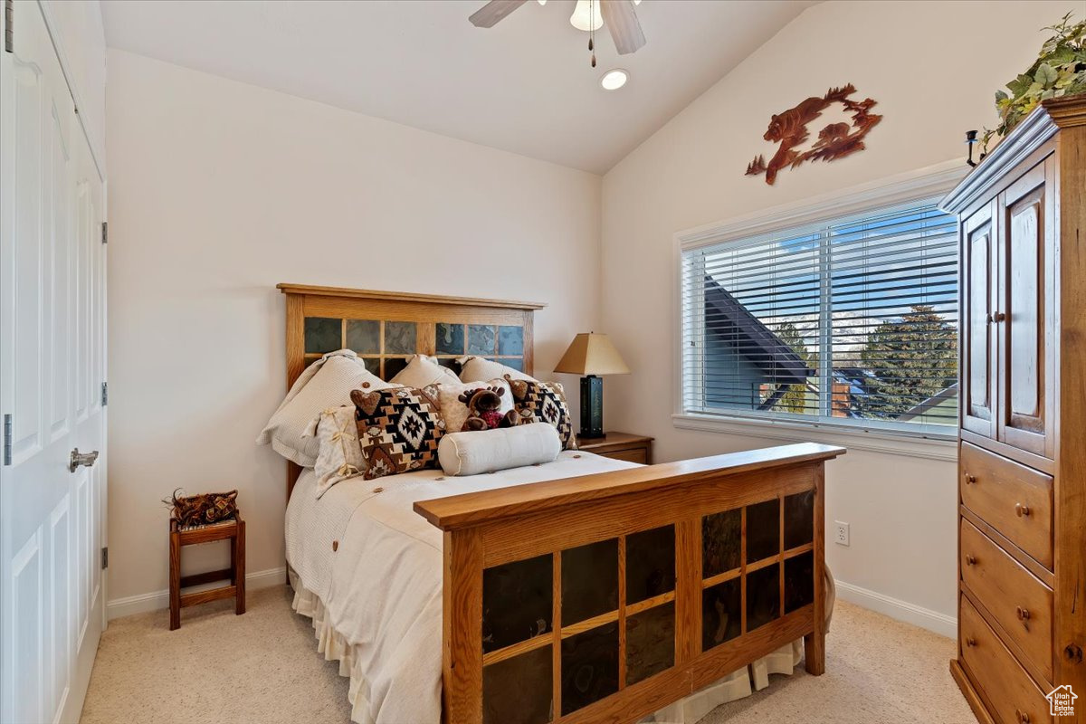 2 of 2 Primary Bedrooms featuring ceiling fan, light colored carpet, and vaulted ceiling