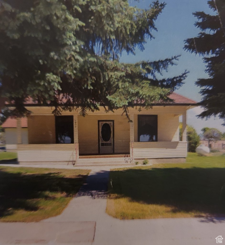 View of front facade featuring a porch and a front lawn