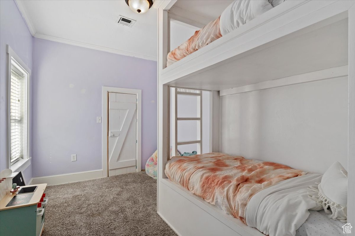 Bedroom with carpet floors and ornamental molding