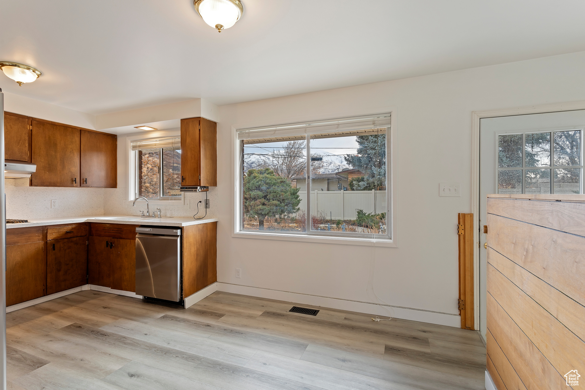 Kitchen with dishwasher, sink, light wood-type flooring, tasteful backsplash, and gas cooktop