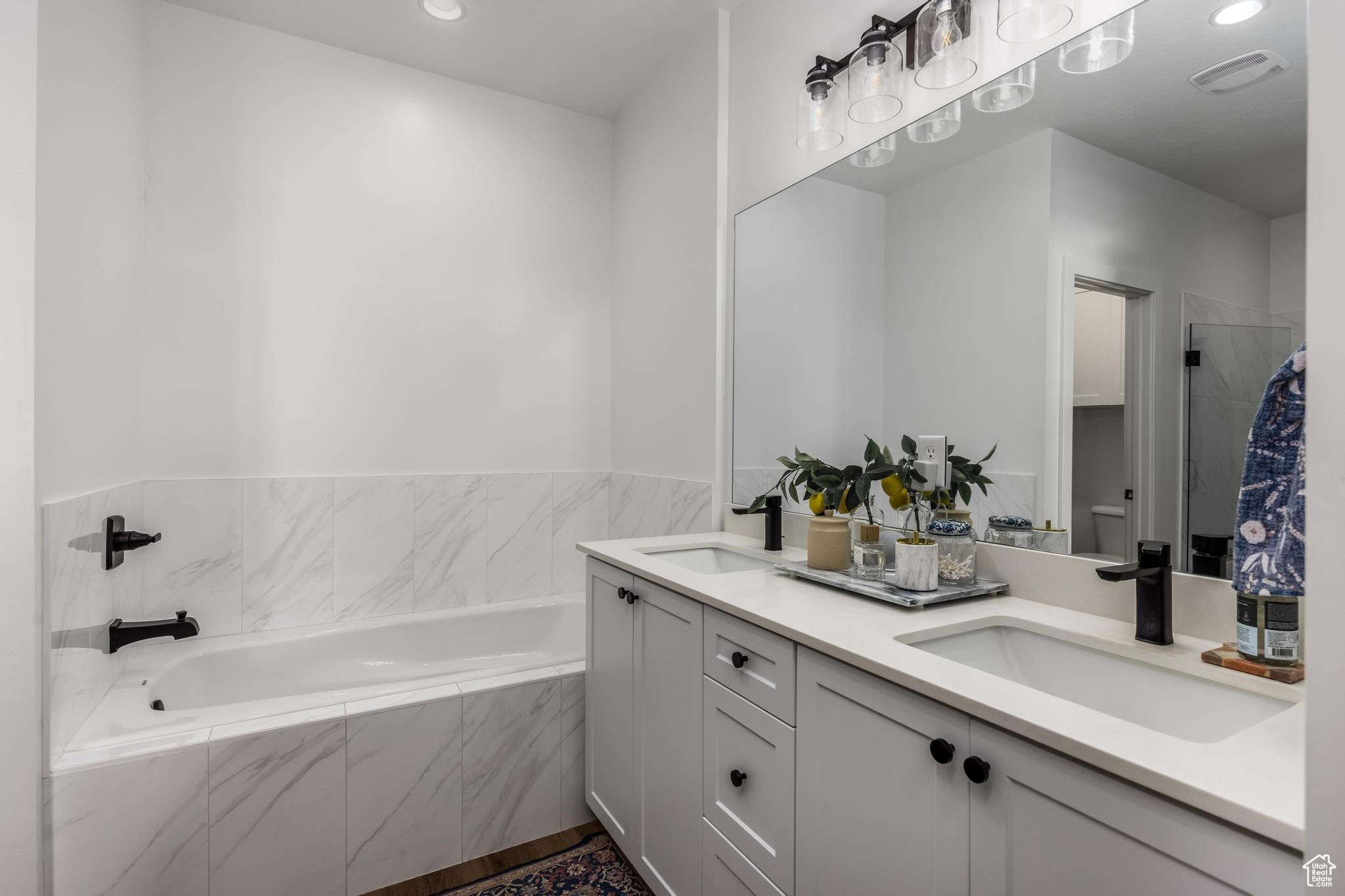 Master Bathroom with vanity and tiled soaking bathtub