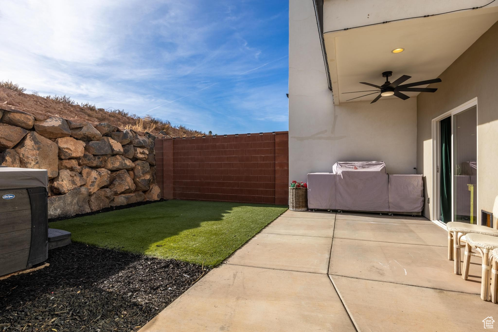 View of yard with ceiling fan and a patio