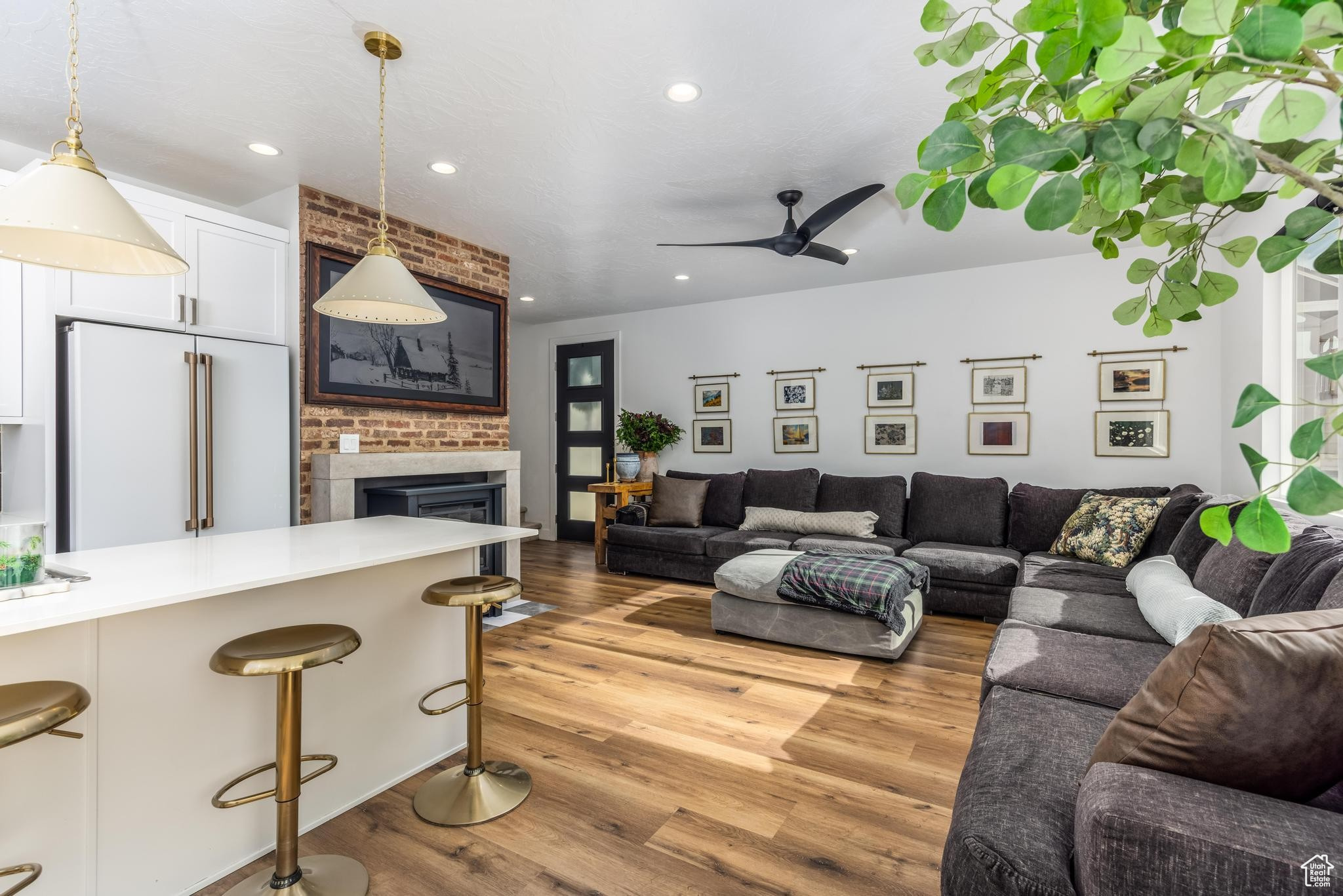 Living room/Great room area with ceiling fan, a fireplace, and light hardwood / wood-style floors