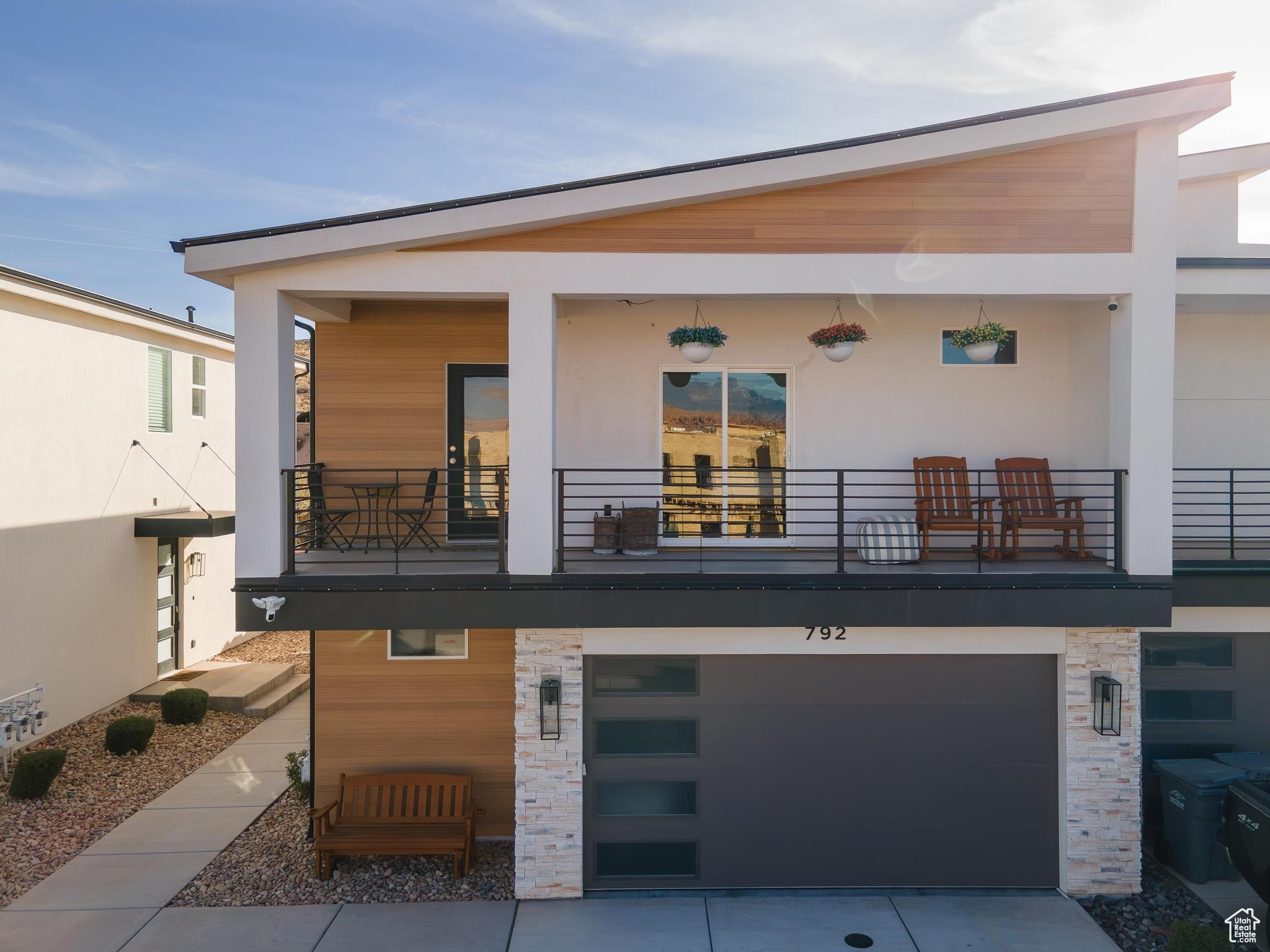 Front view of property featuring a balcony and a garage