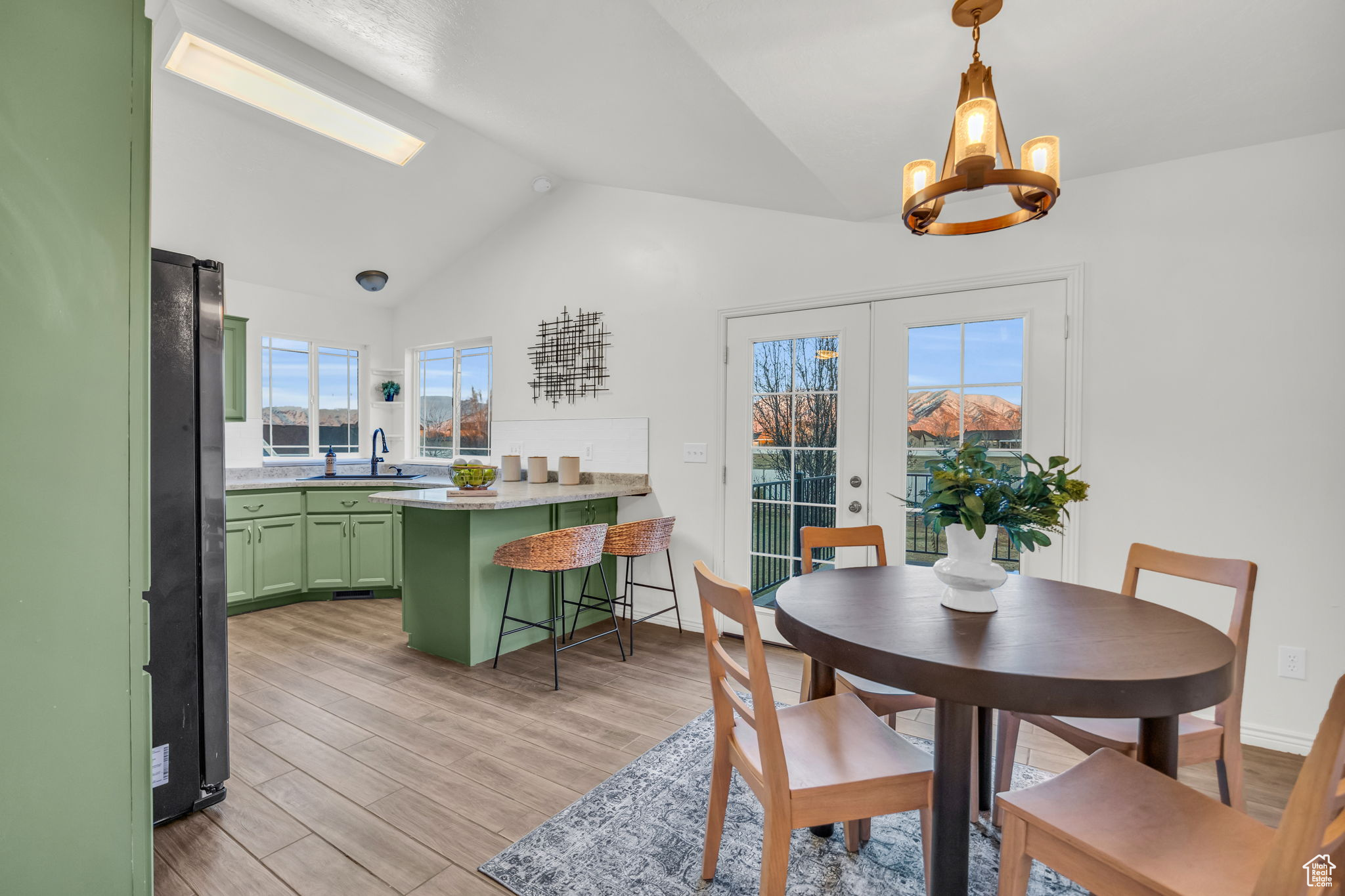 Dining room with french doors, sink, an inviting chandelier, tile wood-style floors, and lofted ceiling