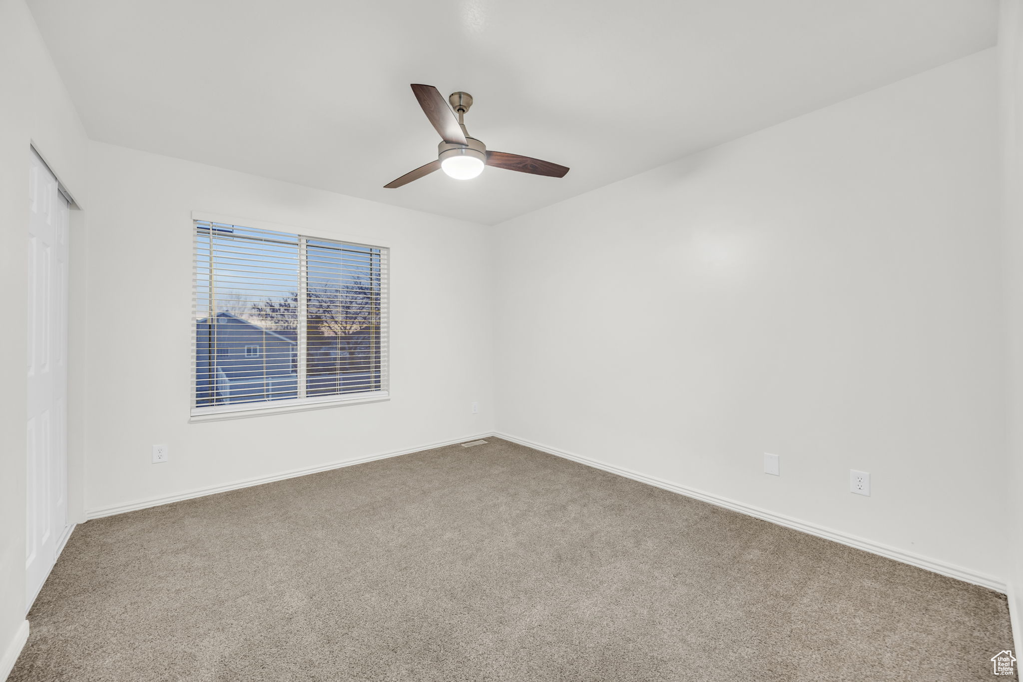 Carpeted empty room with ceiling fan