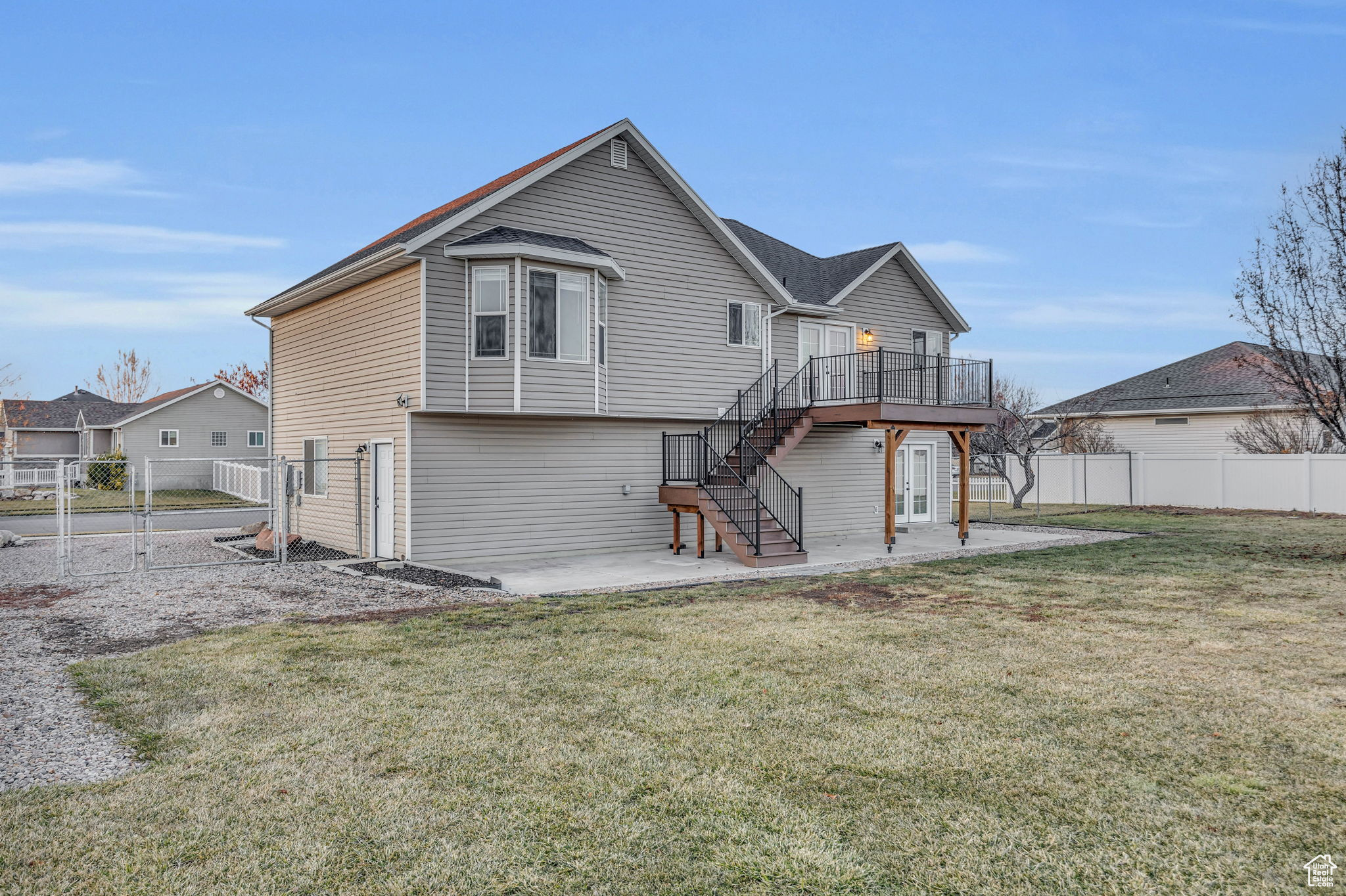 Rear view of house featuring a lawn, a patio, and a deck