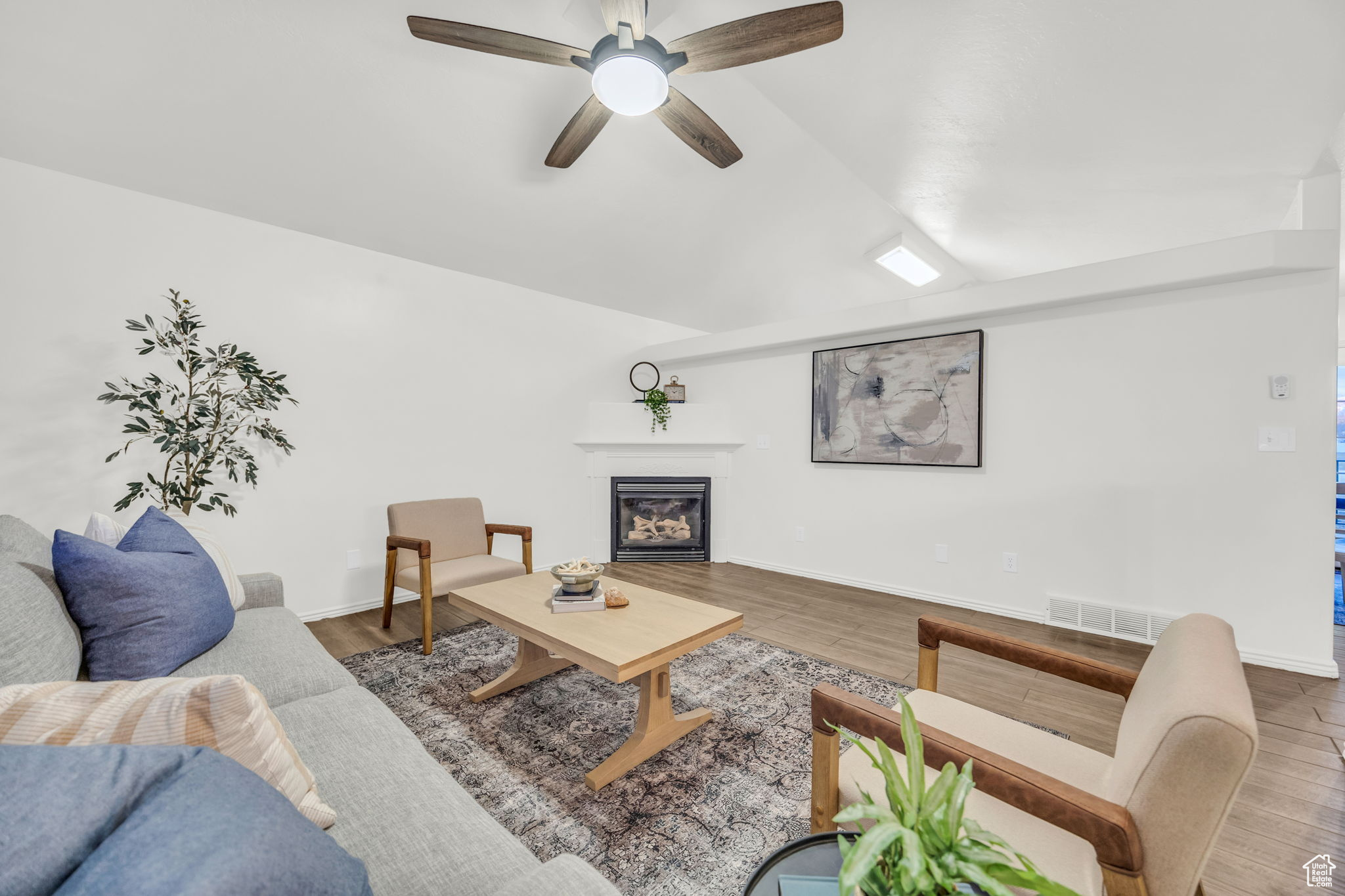 Living room with tile wood-style floors, ceiling fan, and vaulted ceiling