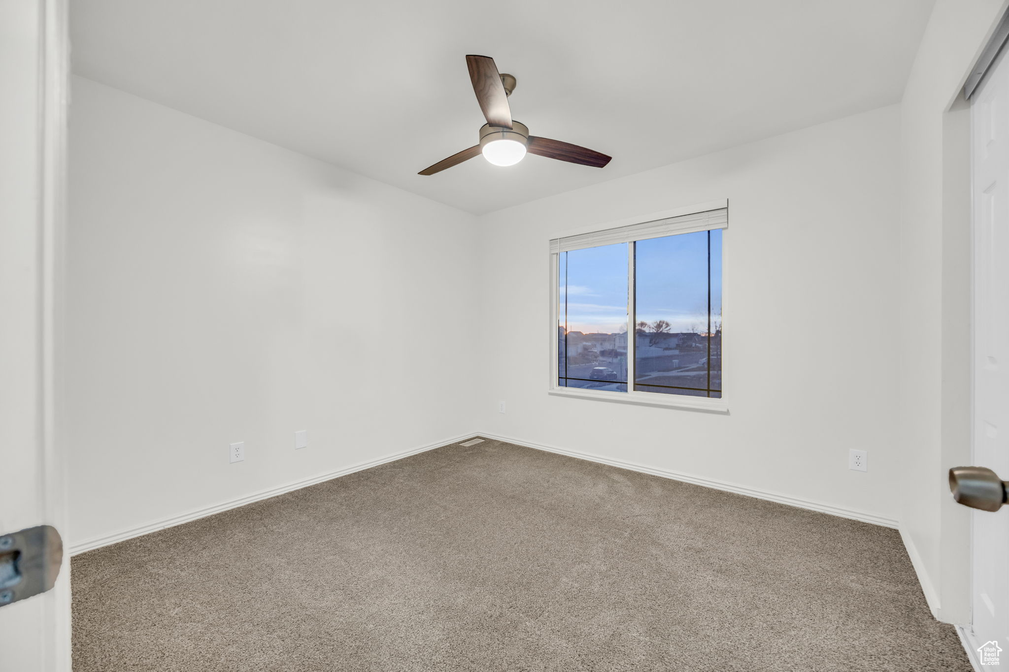 Spare room with carpet flooring and ceiling fan