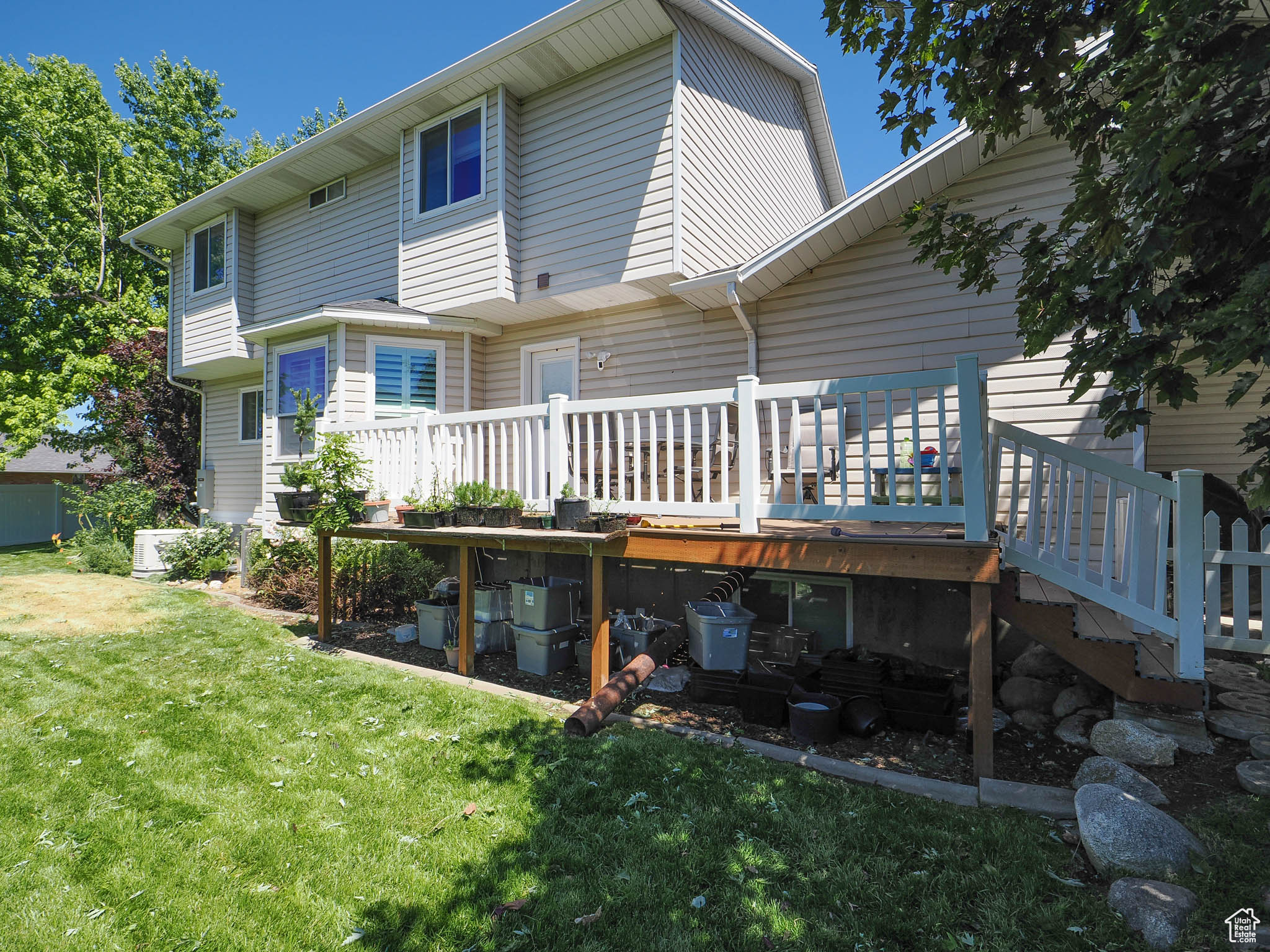 Rear view of house with a lawn and a wooden deck