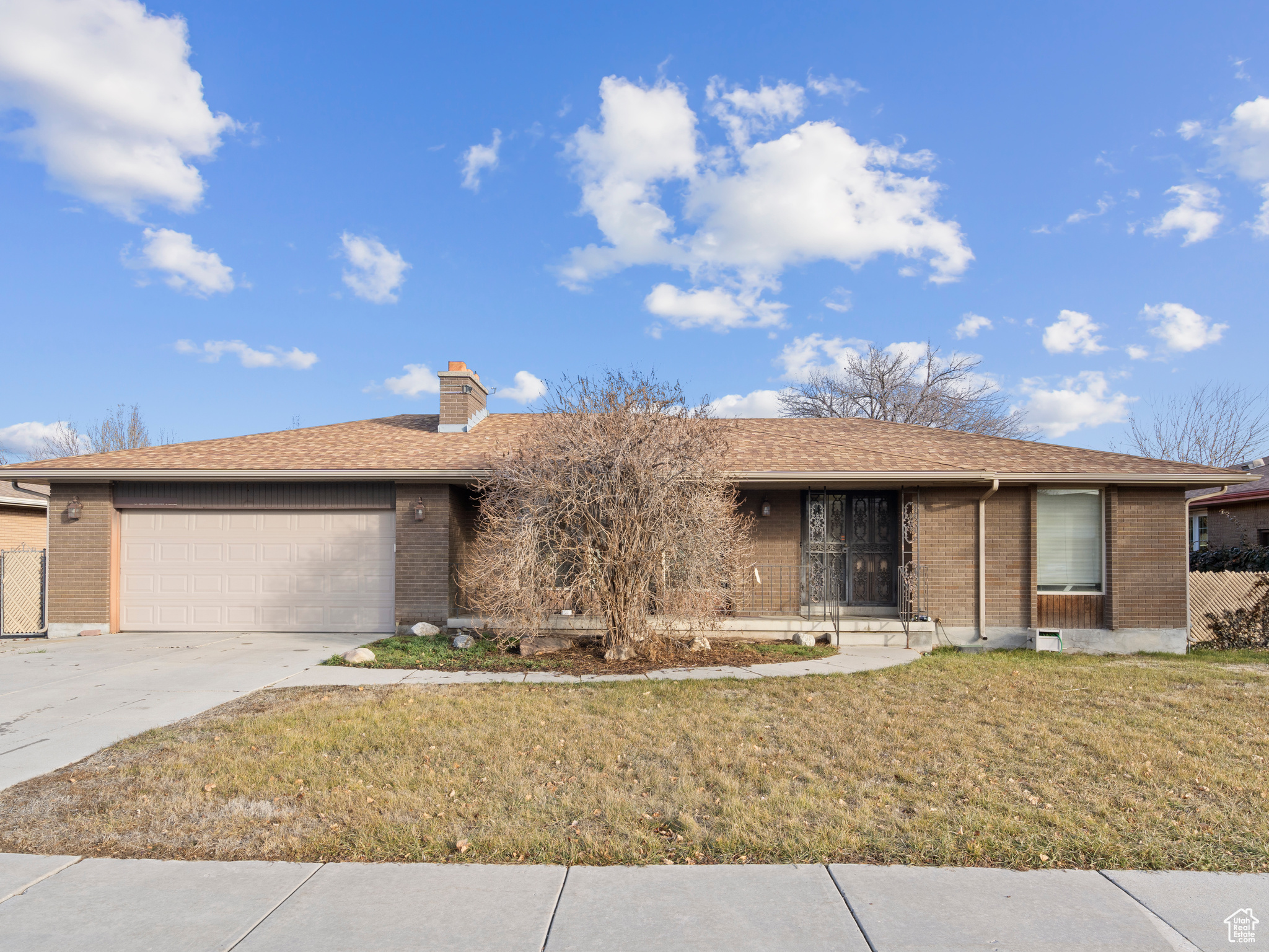 Ranch-style home with a front lawn and a garage