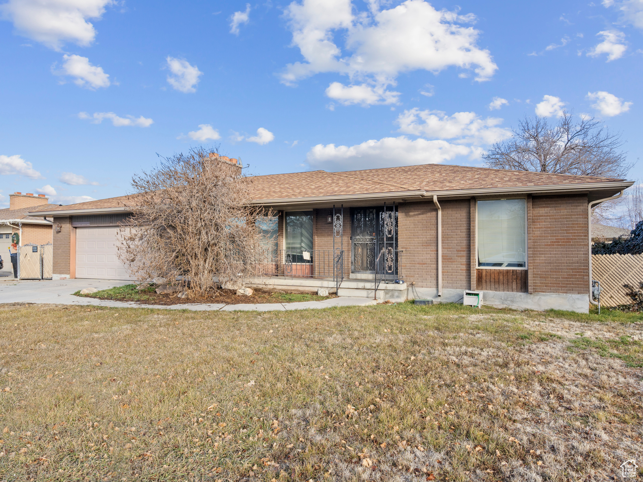 Single story home with a garage and a front lawn