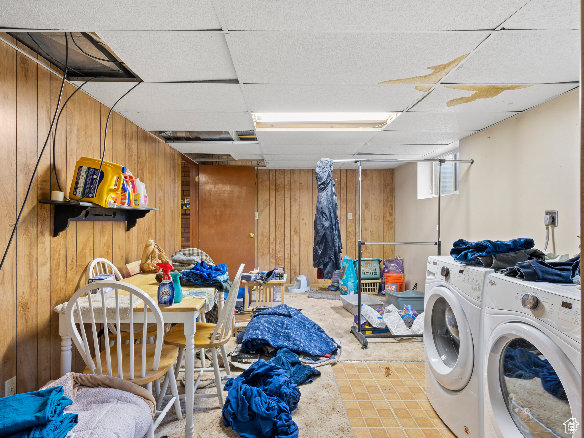 Laundry area featuring separate washer and dryer and wood walls