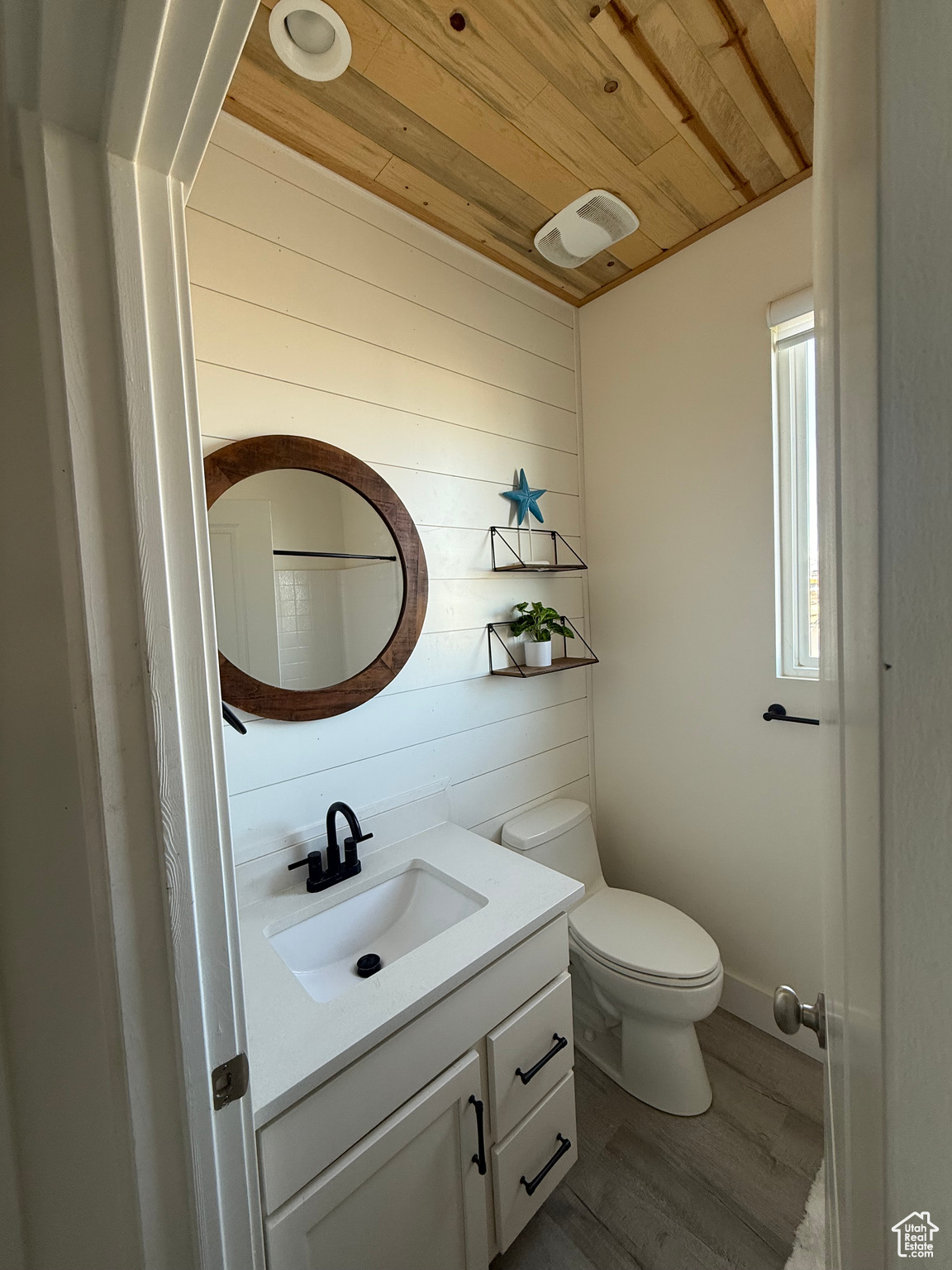 Bathroom with vanity, wood walls, wooden ceiling, hardwood / wood-style flooring, and toilet