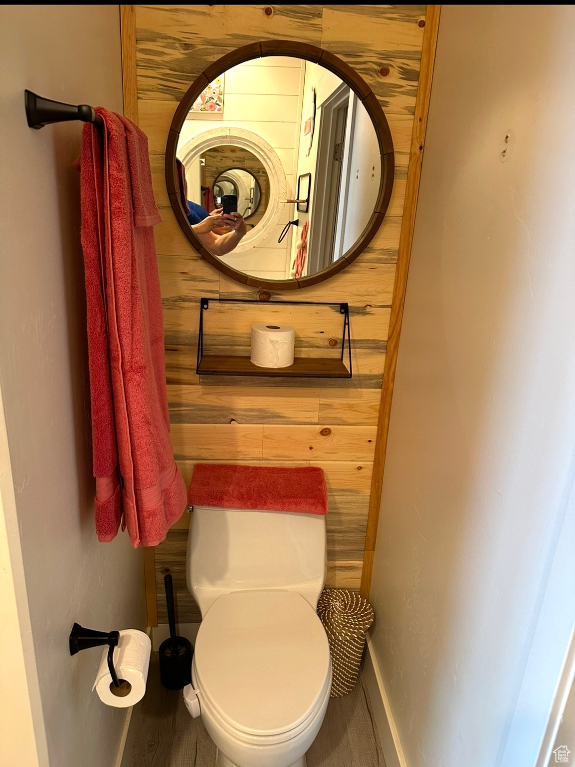 Bathroom featuring wood walls and toilet