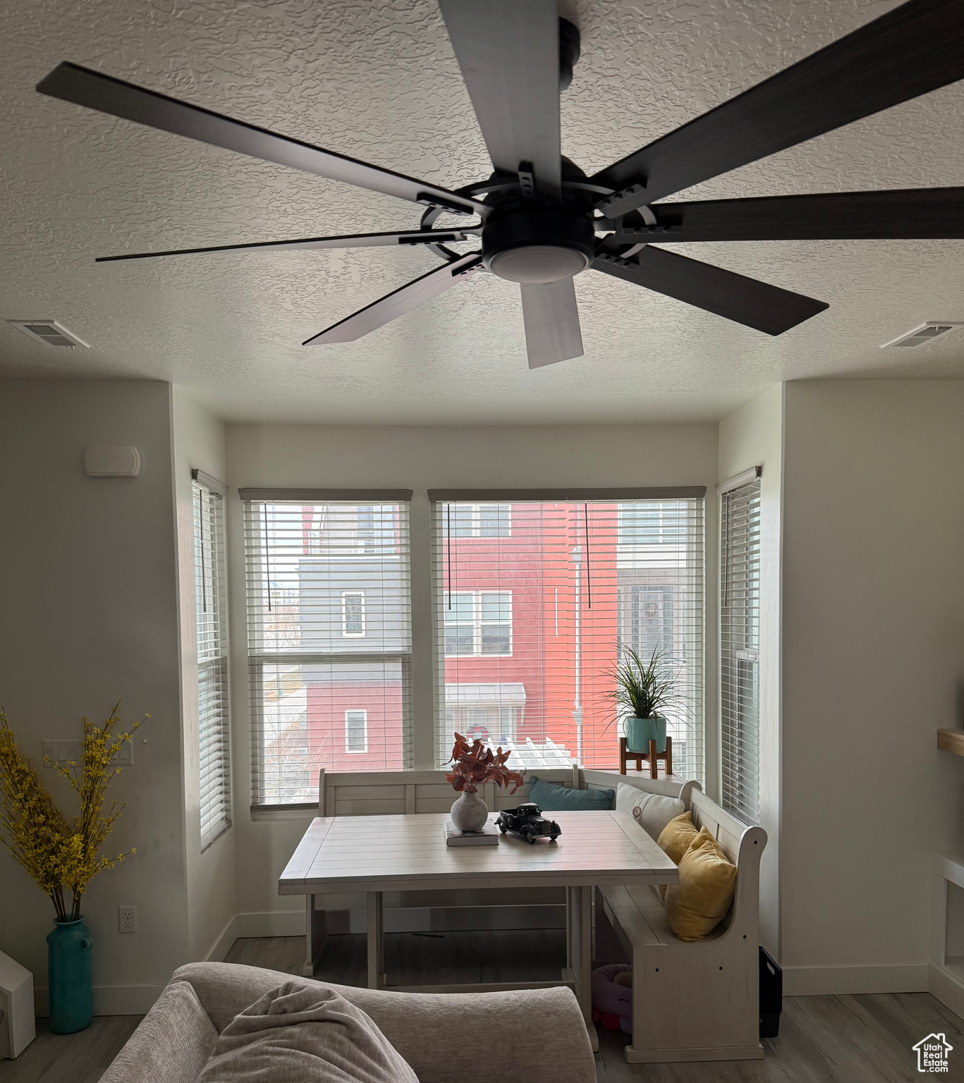 Dining space with light wood-type flooring, a wealth of natural light, and ceiling fan