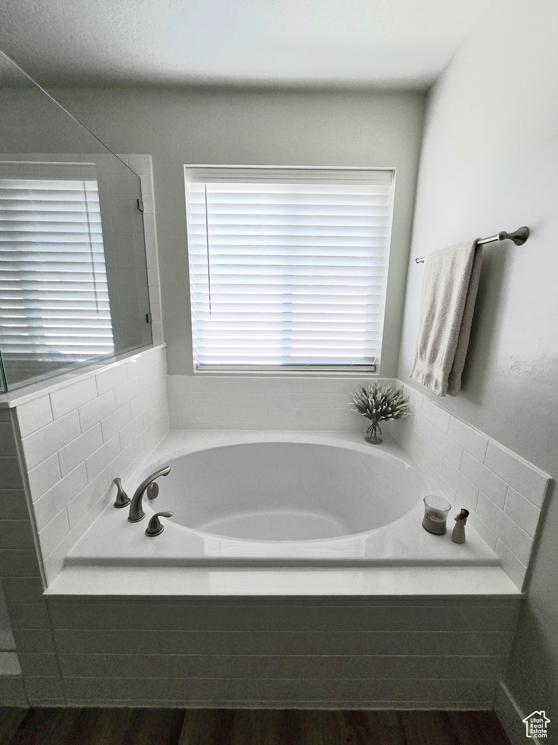 Bathroom with wood-type flooring and tiled bath