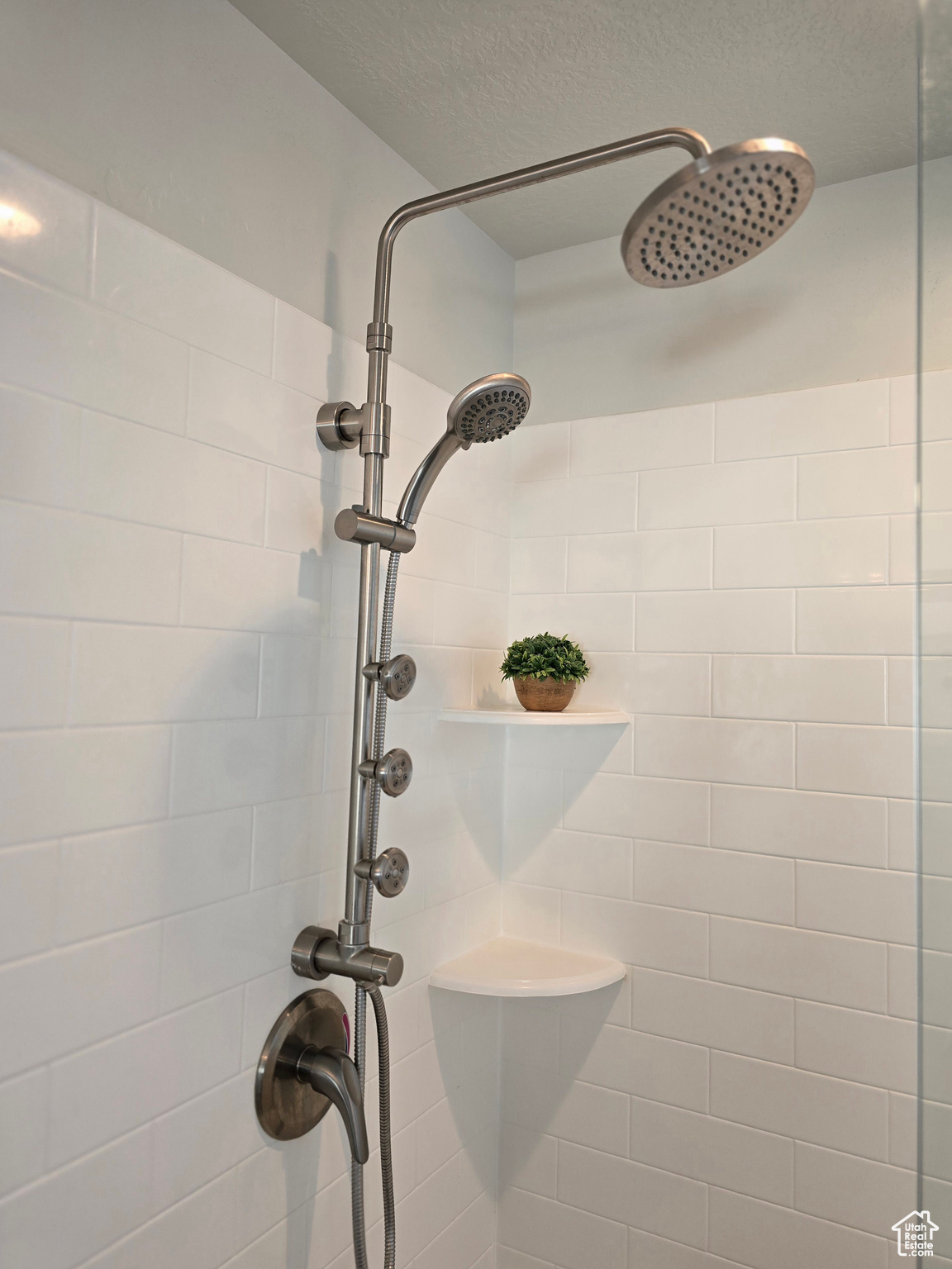 Room details with a textured ceiling and tiled shower