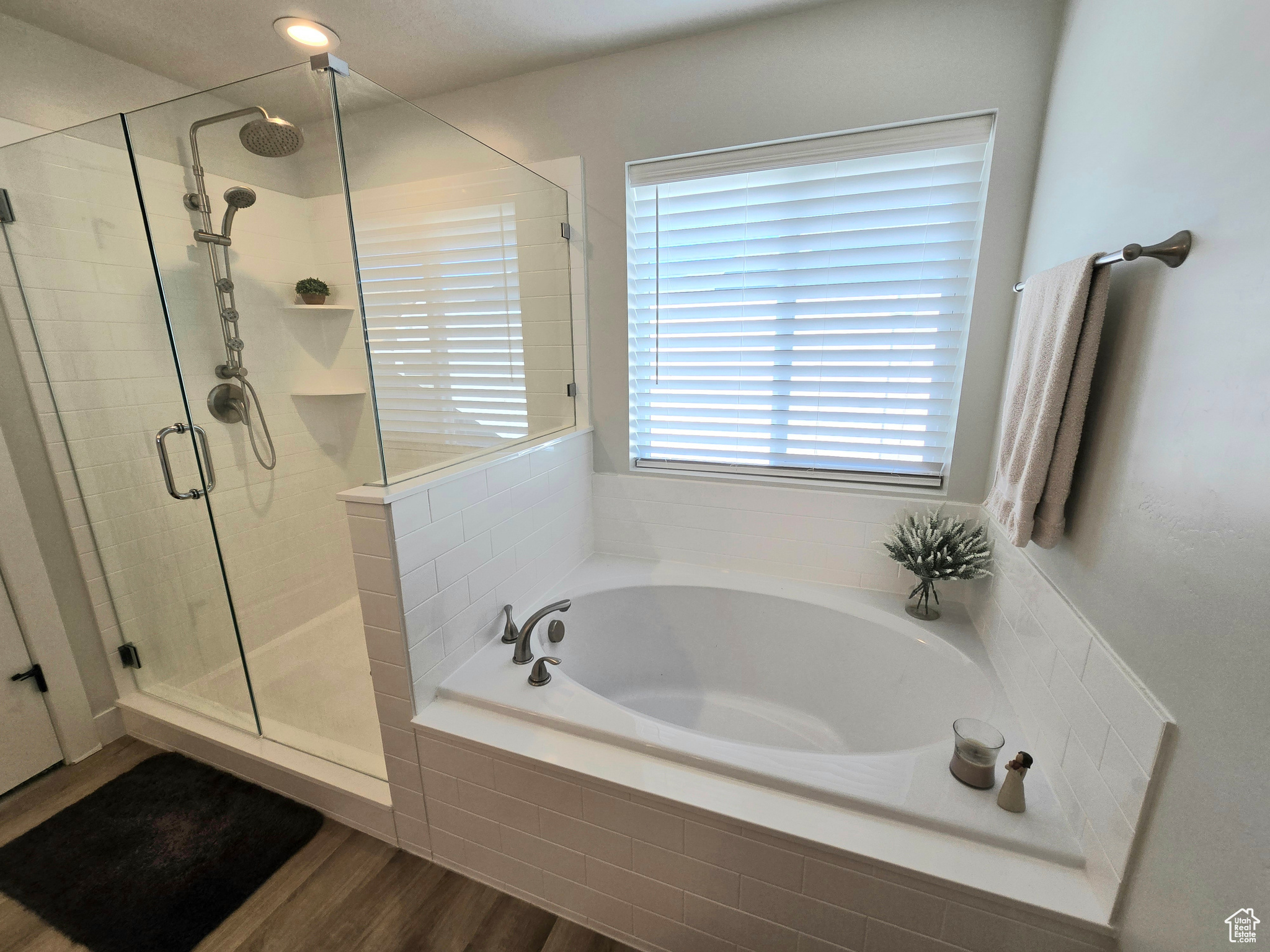 Bathroom featuring separate shower and tub, a healthy amount of sunlight, and wood-type flooring