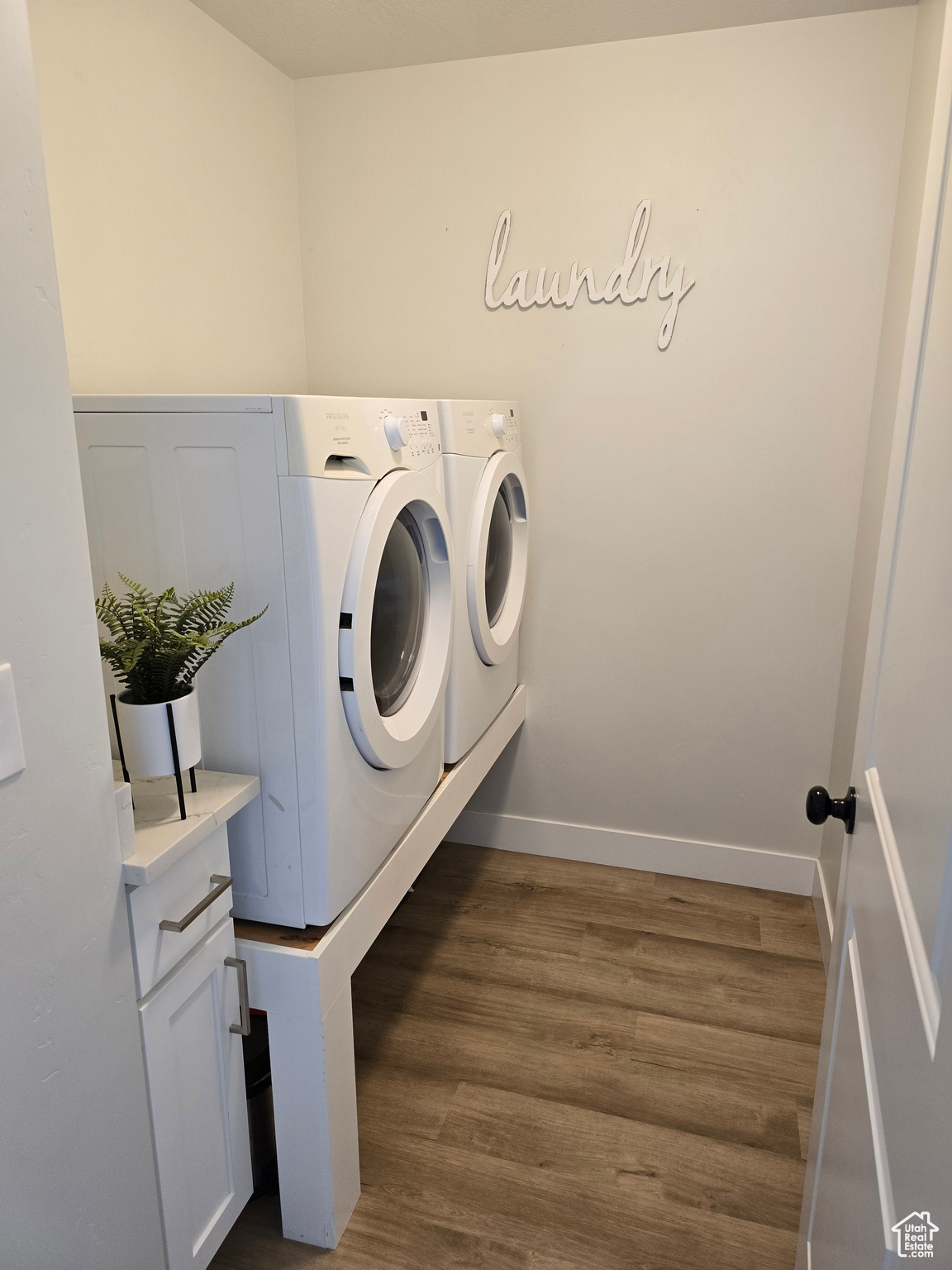 Laundry room featuring washer and dryer and  wood-type flooring