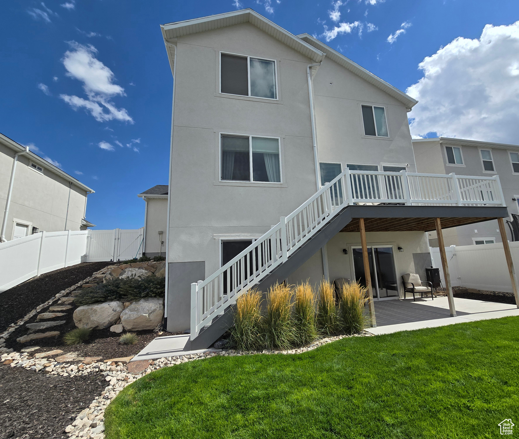 Back of property with a patio area, a yard, and a wooden deck