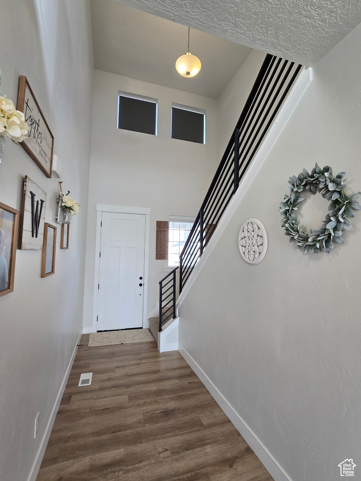 Foyer with a high ceiling and wood-type flooring