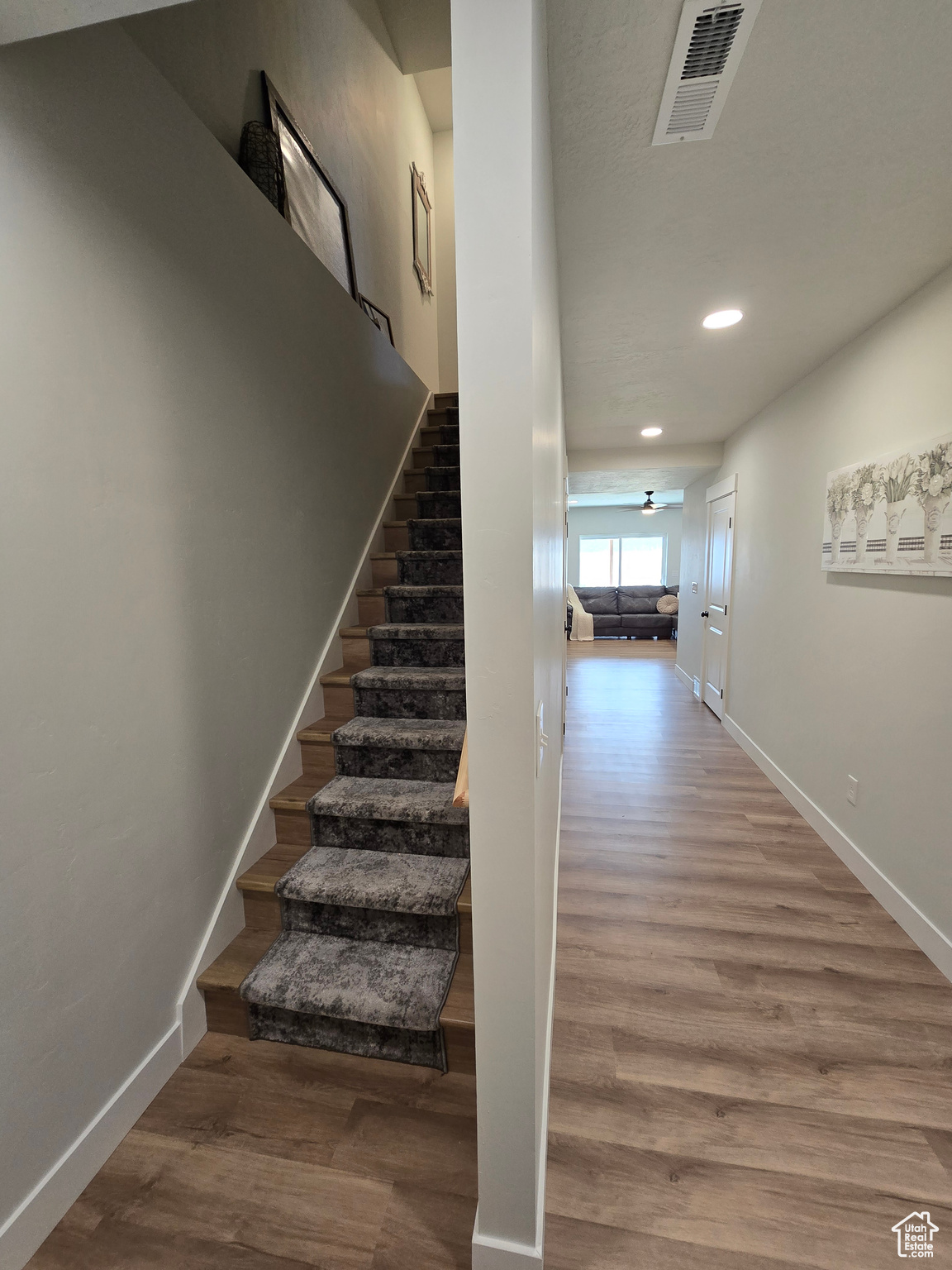 Stairway with ceiling fan and wood-type flooring