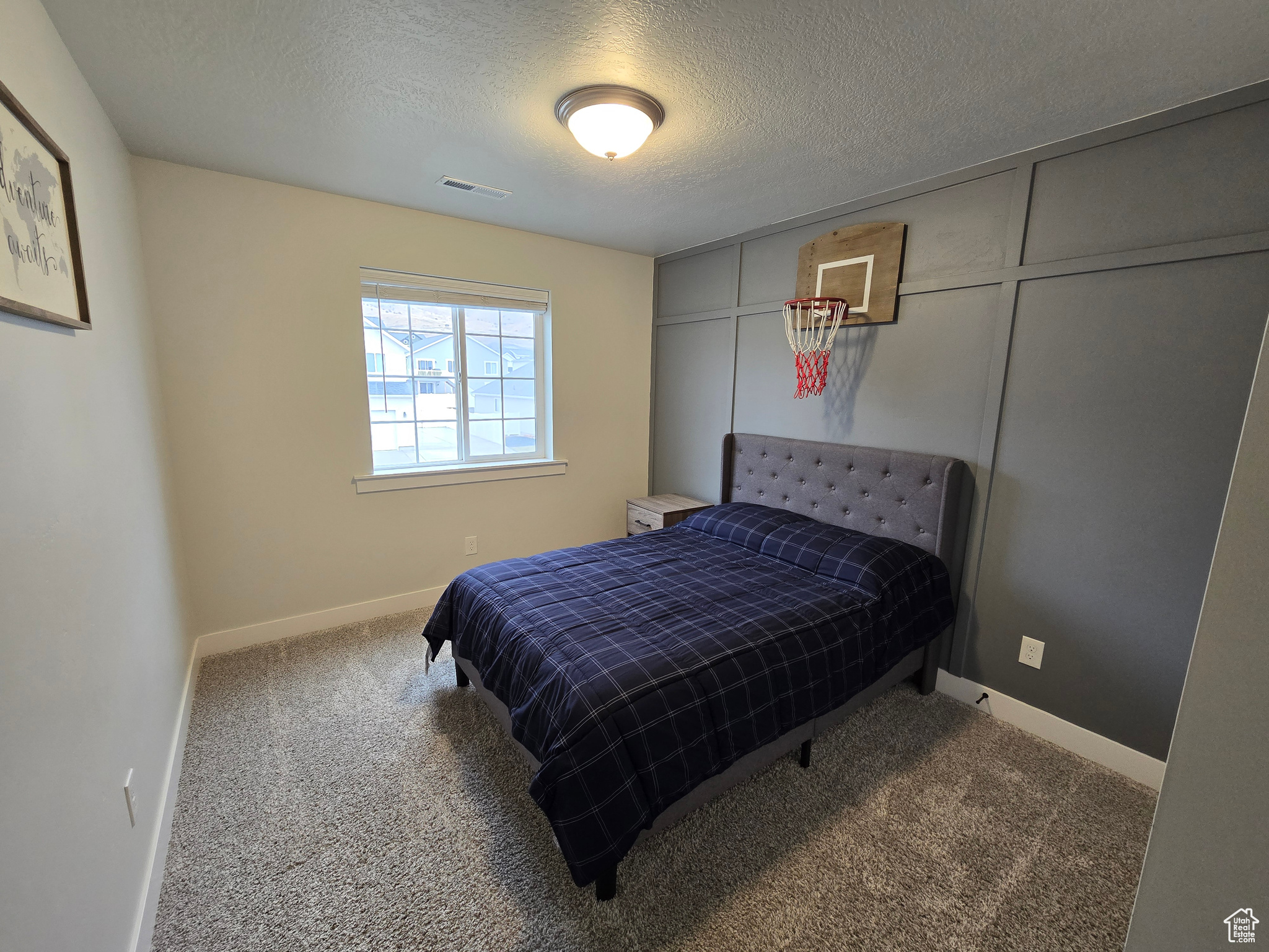 Bedroom with a textured ceiling and carpet floors