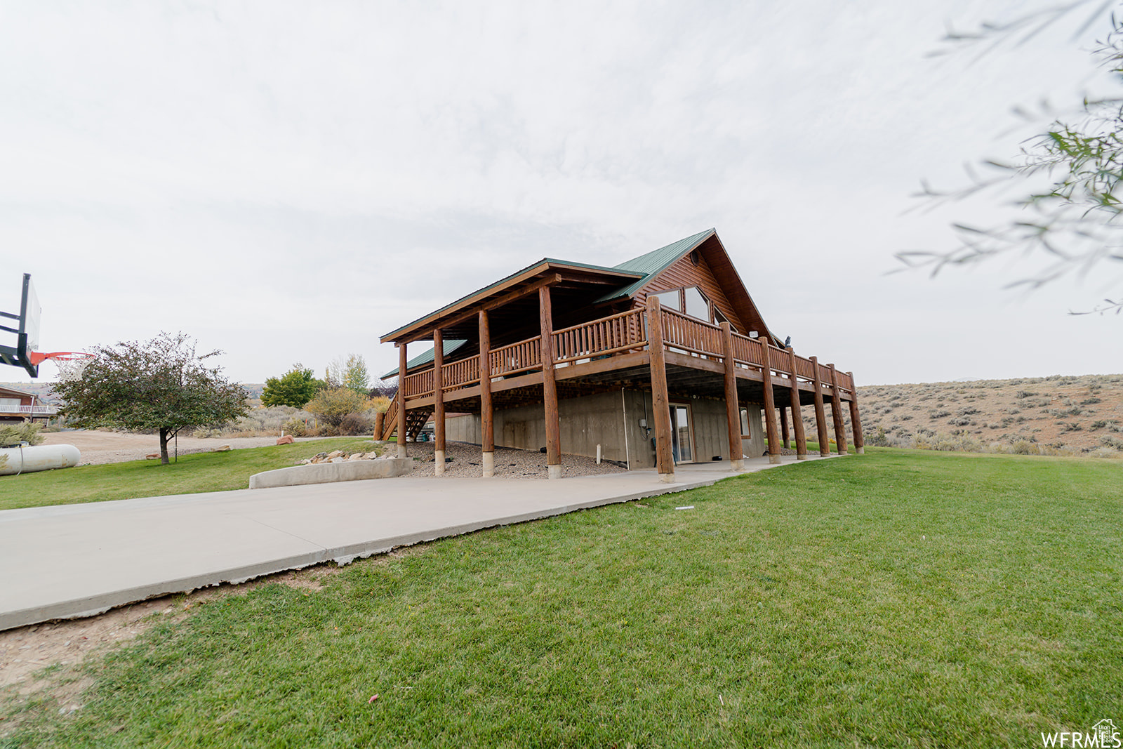 Back of house featuring a yard and a wooden deck