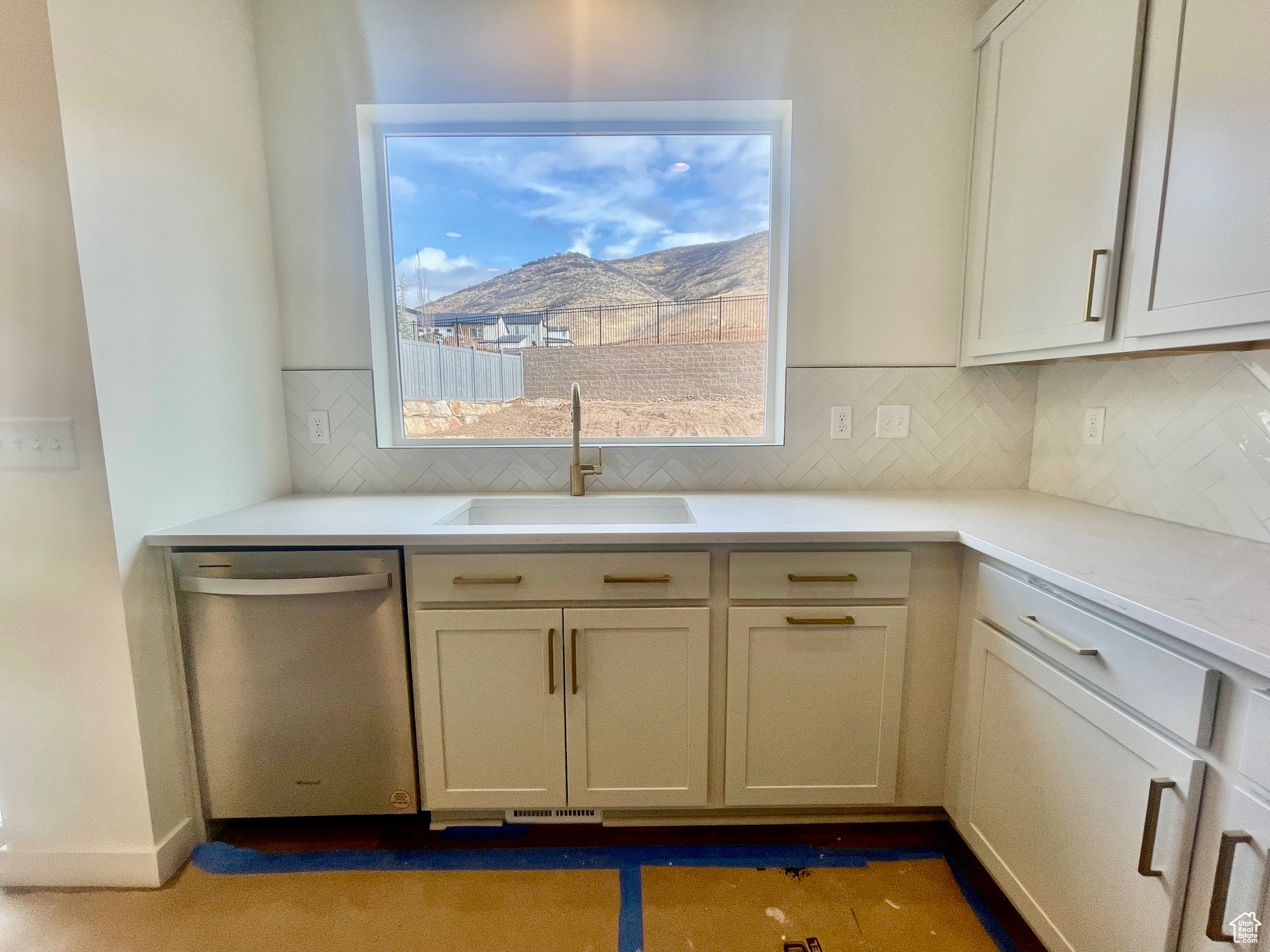 Kitchen featuring dishwasher, a mountain view, tasteful backsplash, and sink