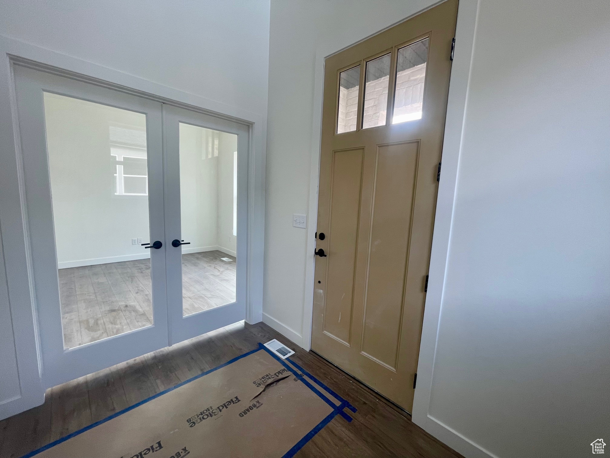 Foyer entrance with french doors and dark hardwood / wood-style floors