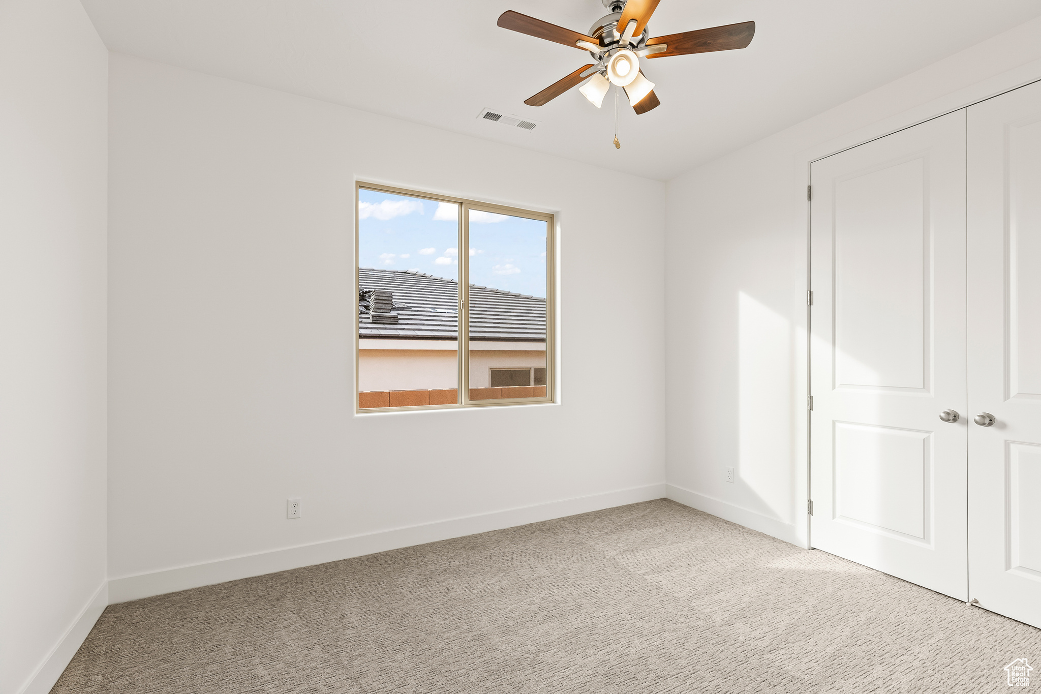 Unfurnished bedroom with a closet, light colored carpet, and ceiling fan