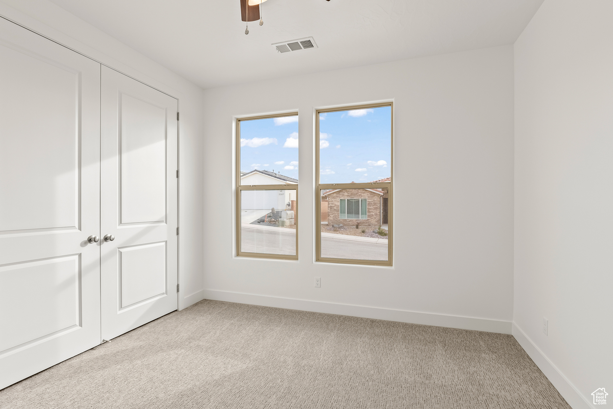 Unfurnished bedroom featuring light carpet, a closet, and ceiling fan