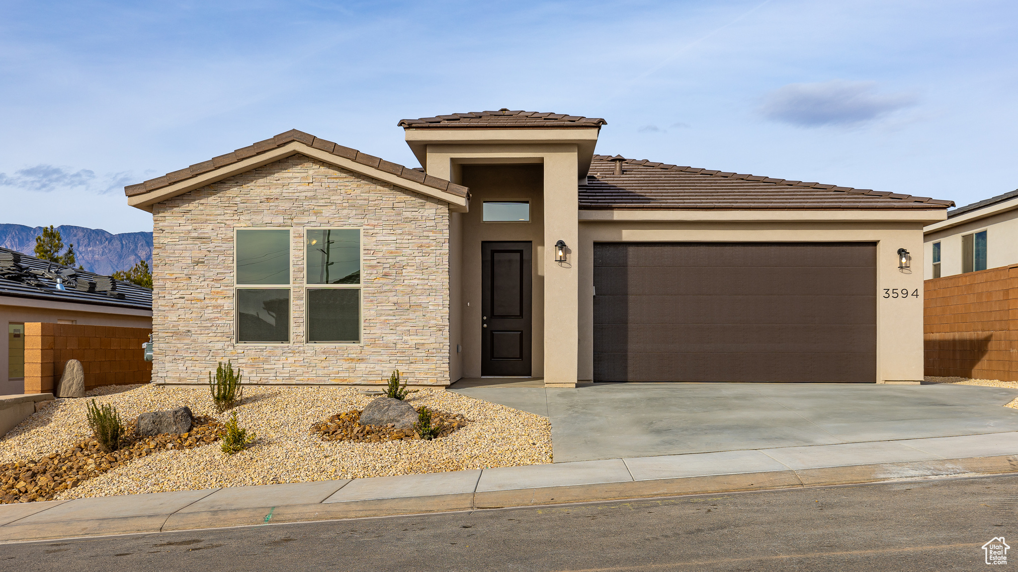 View of front of home with a mountain view and a garage