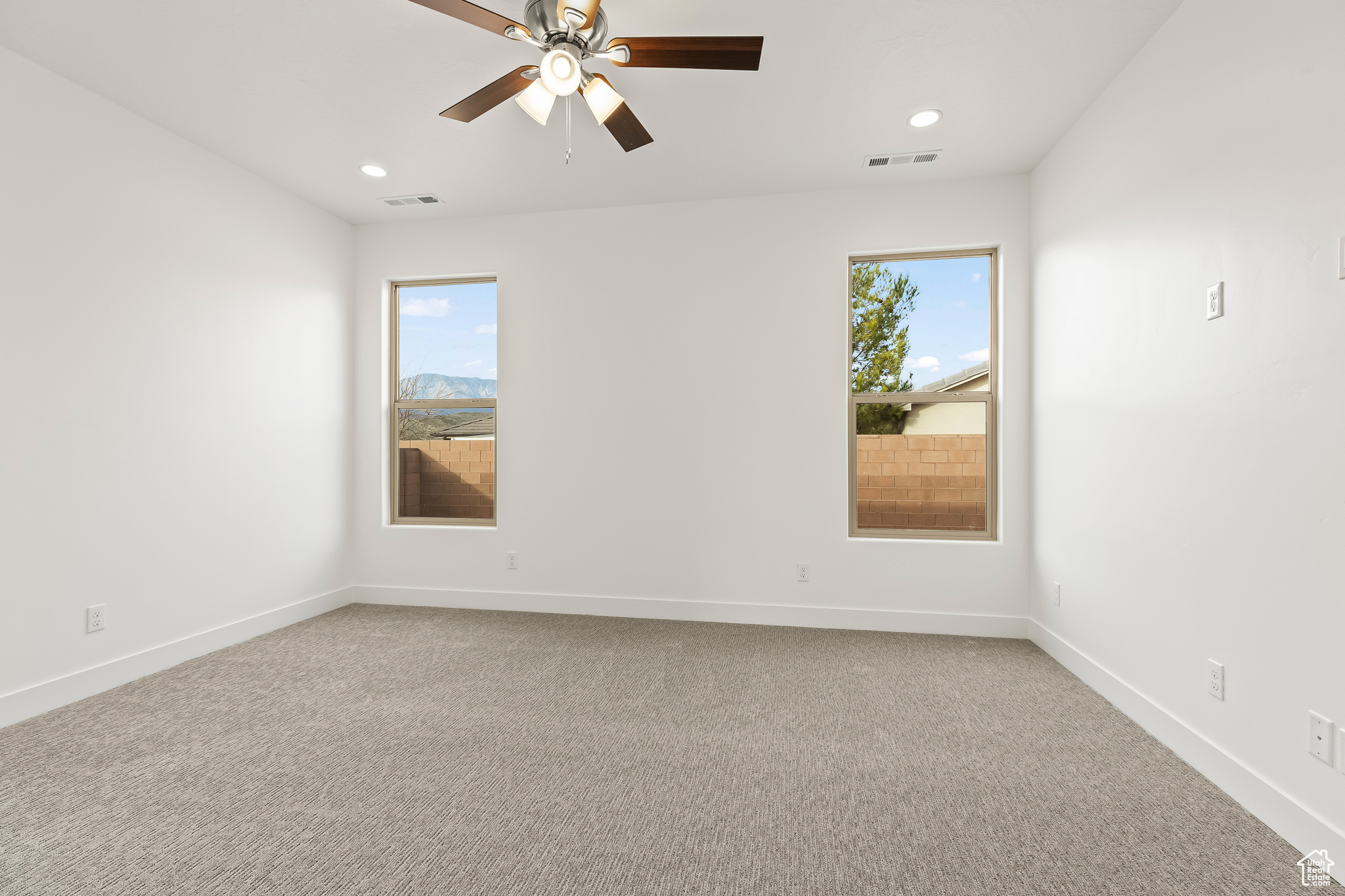 Carpeted spare room featuring ceiling fan